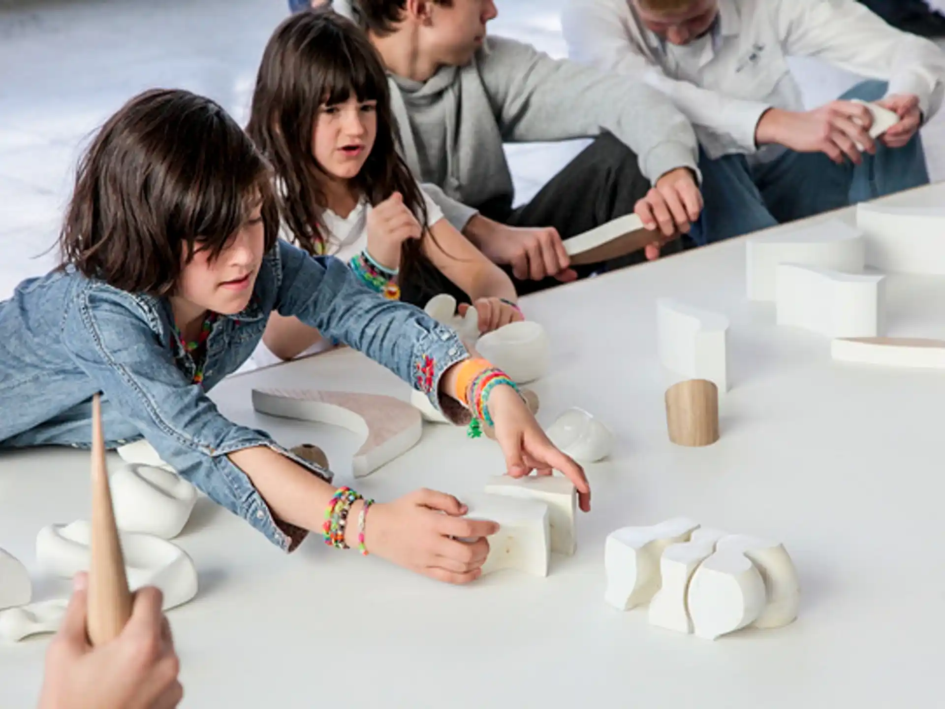 a group of people sitting around a table with white blocks