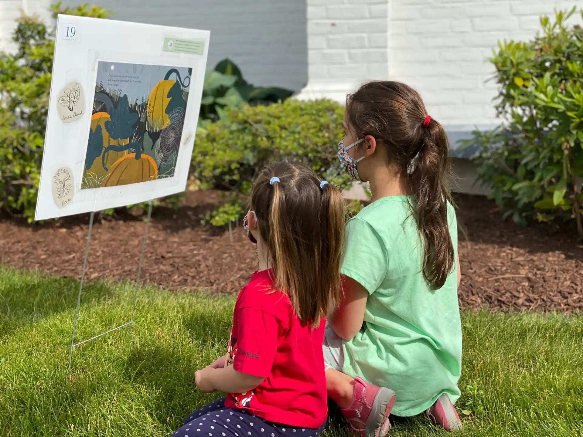 a group of girls looking at a picture on a wall