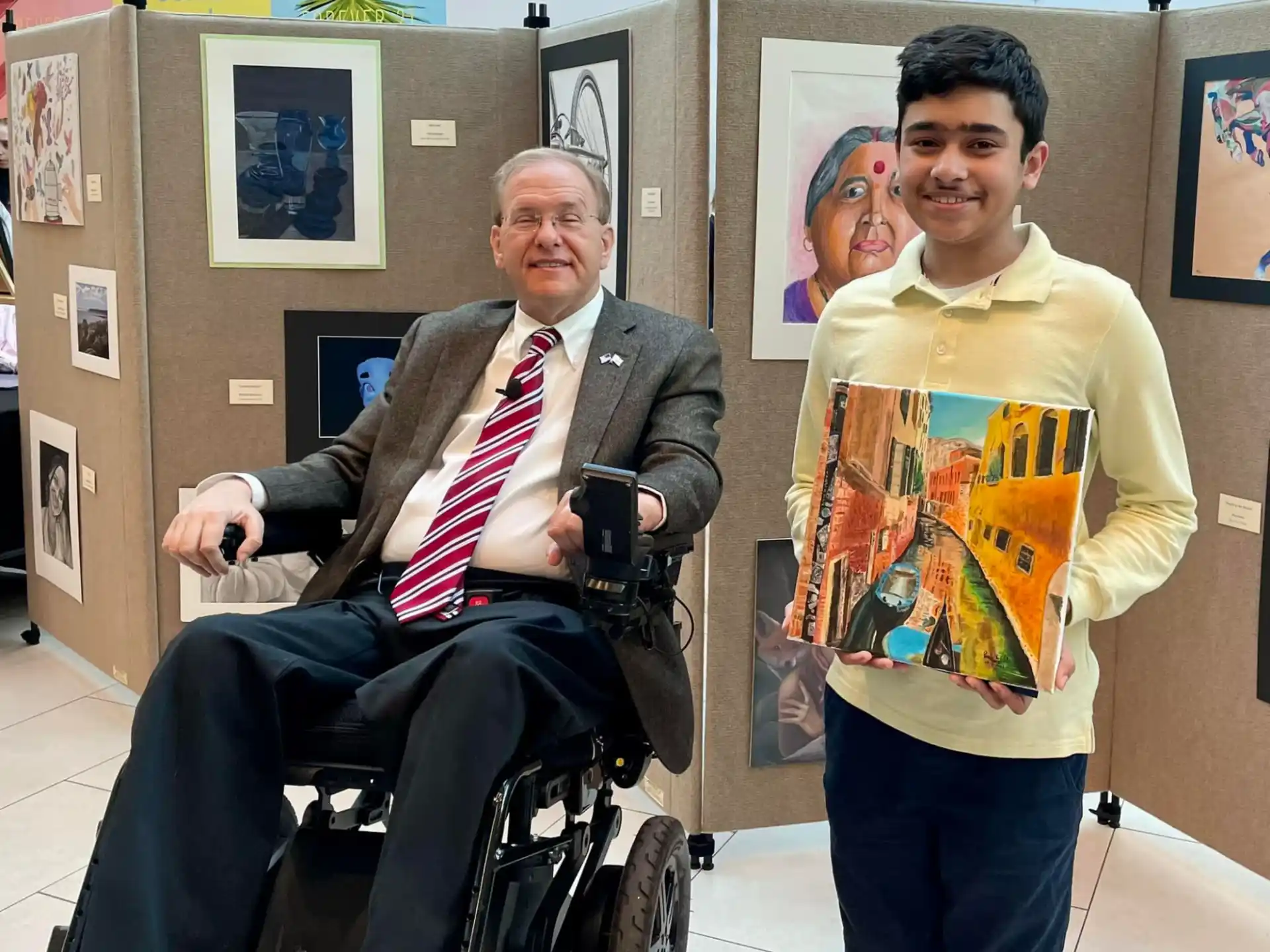 a person in a wheelchair with a boy standing next to him