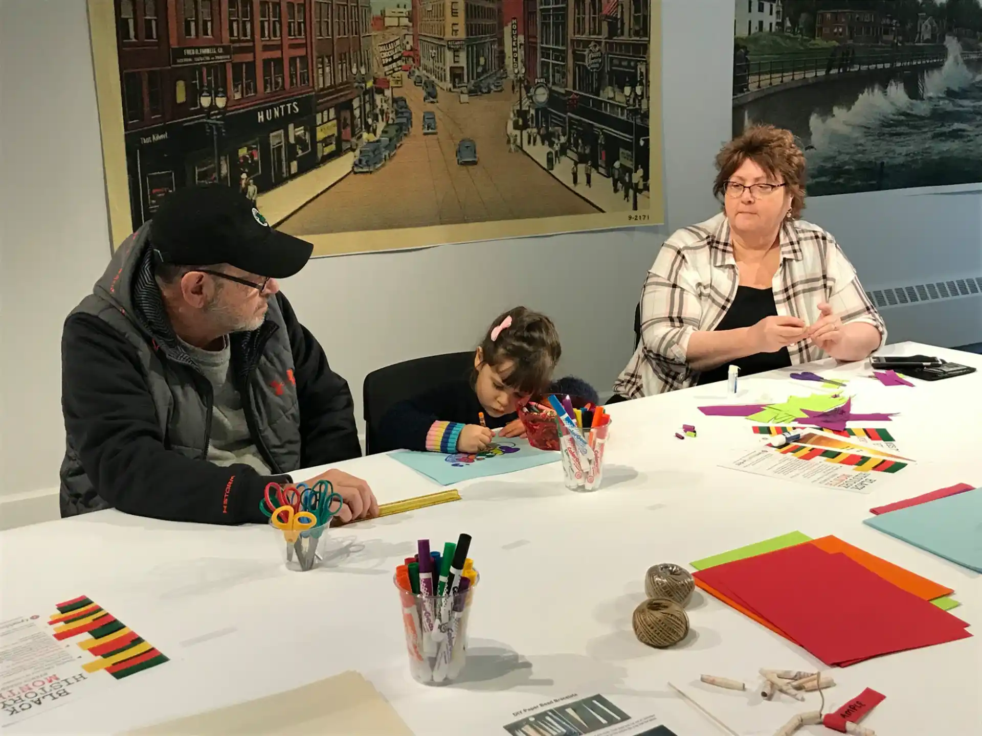 a group of people sitting at a table with colorful pieces of paper