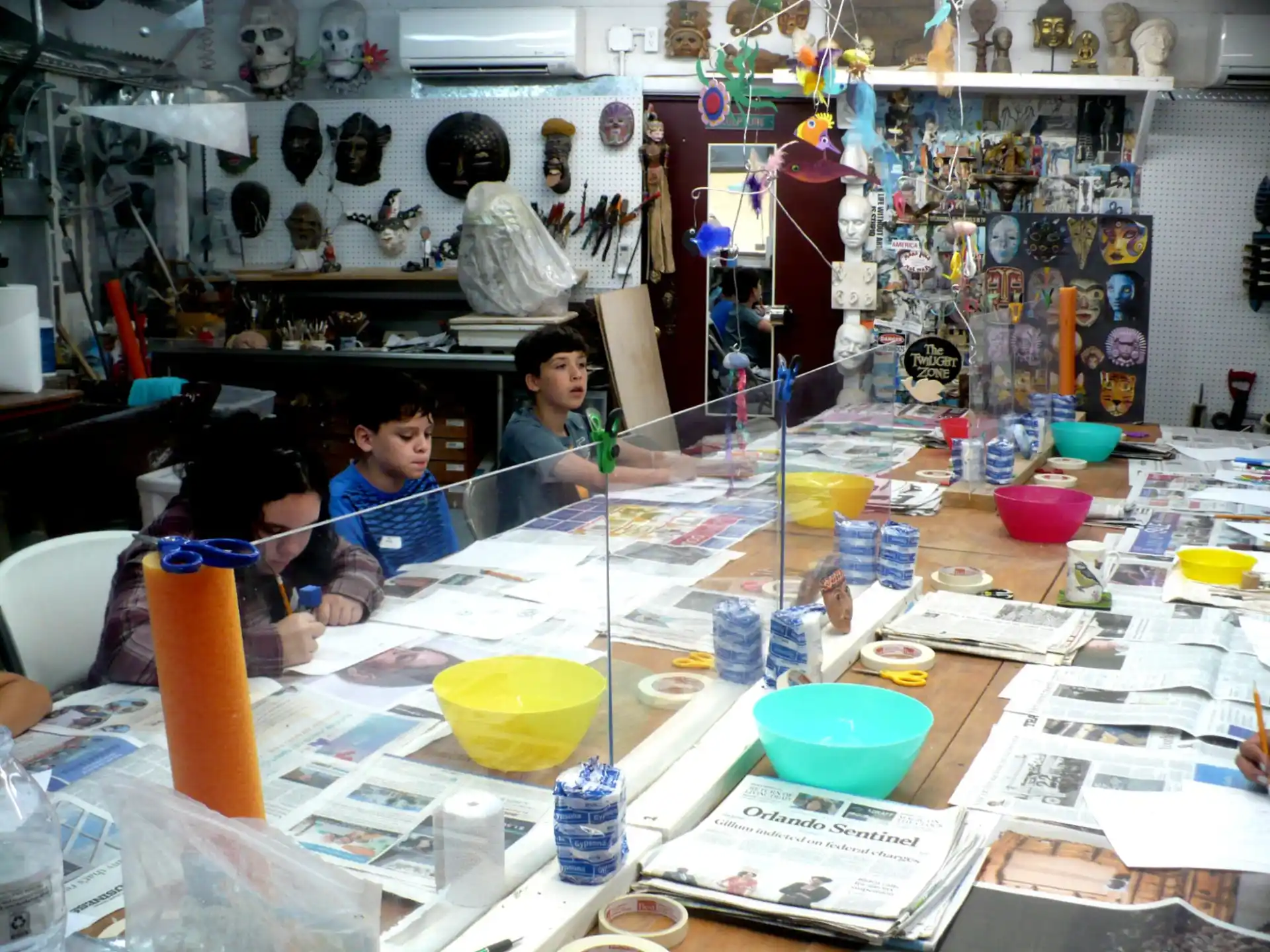 a couple of people in a room with many objects on the table
