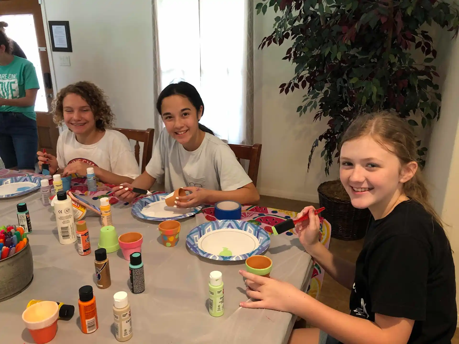 a group of women sitting at a table eating food
