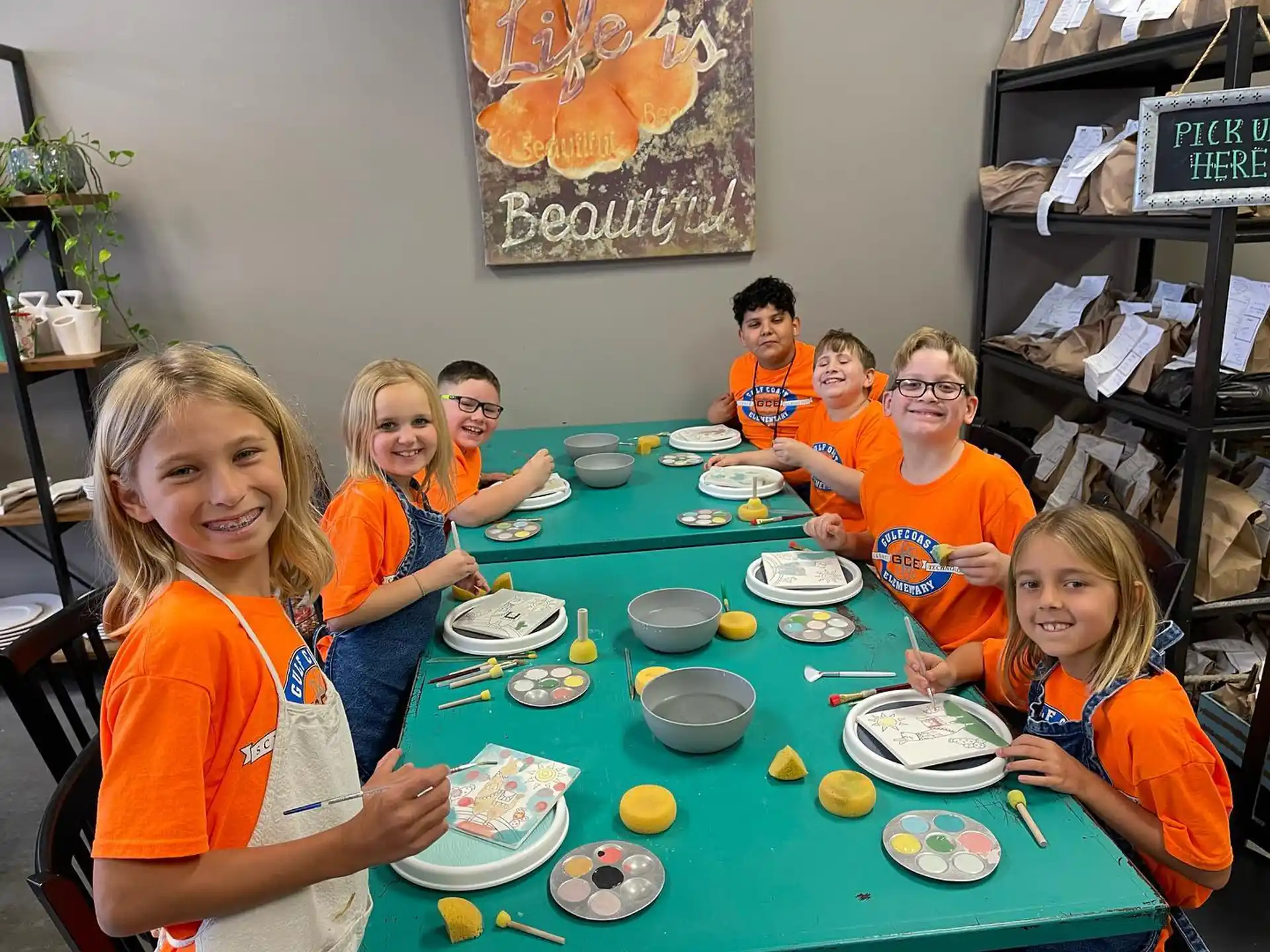 a group of children sitting at a table eating food