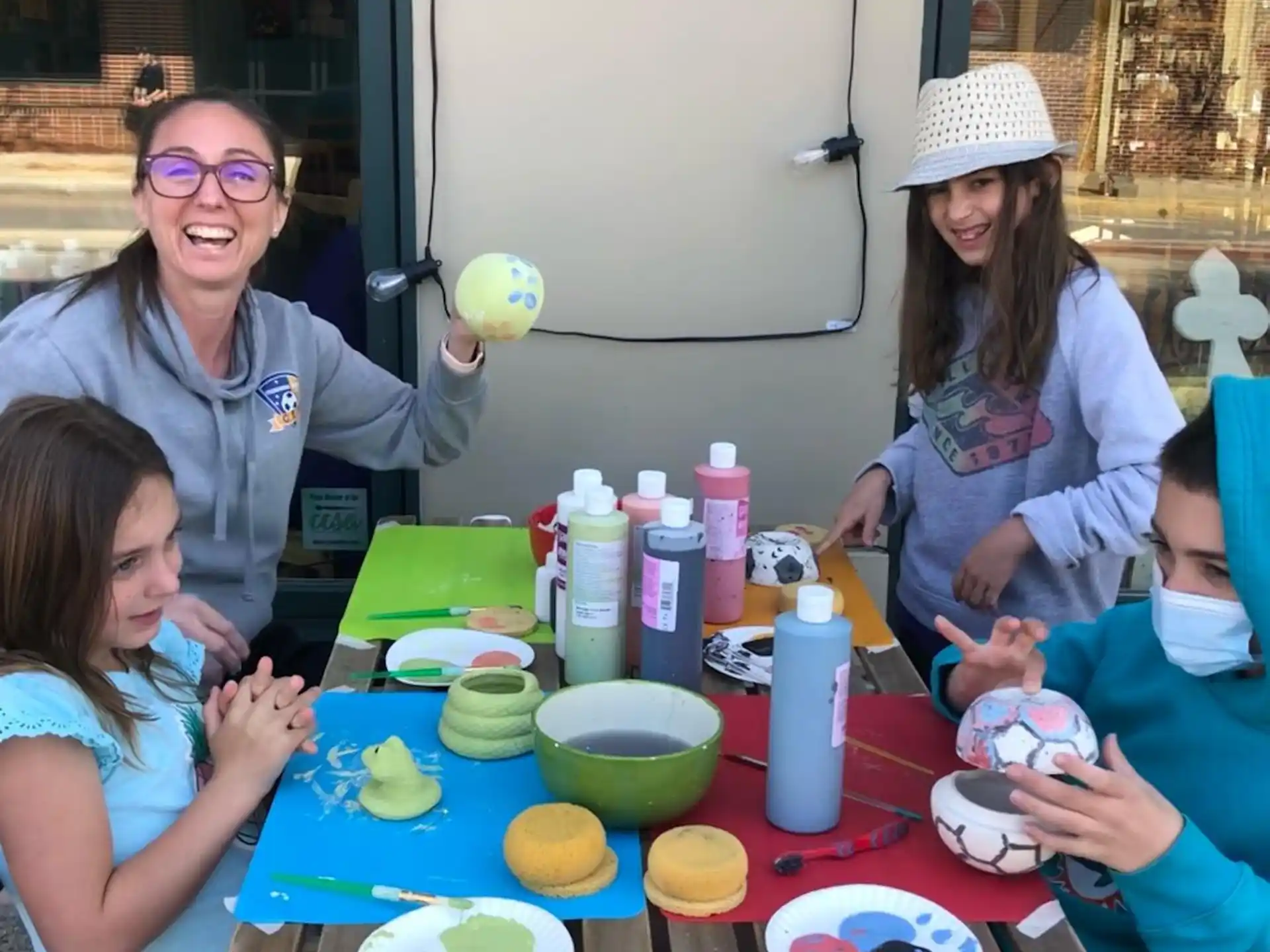 a group of people sitting at a table with food and drinks