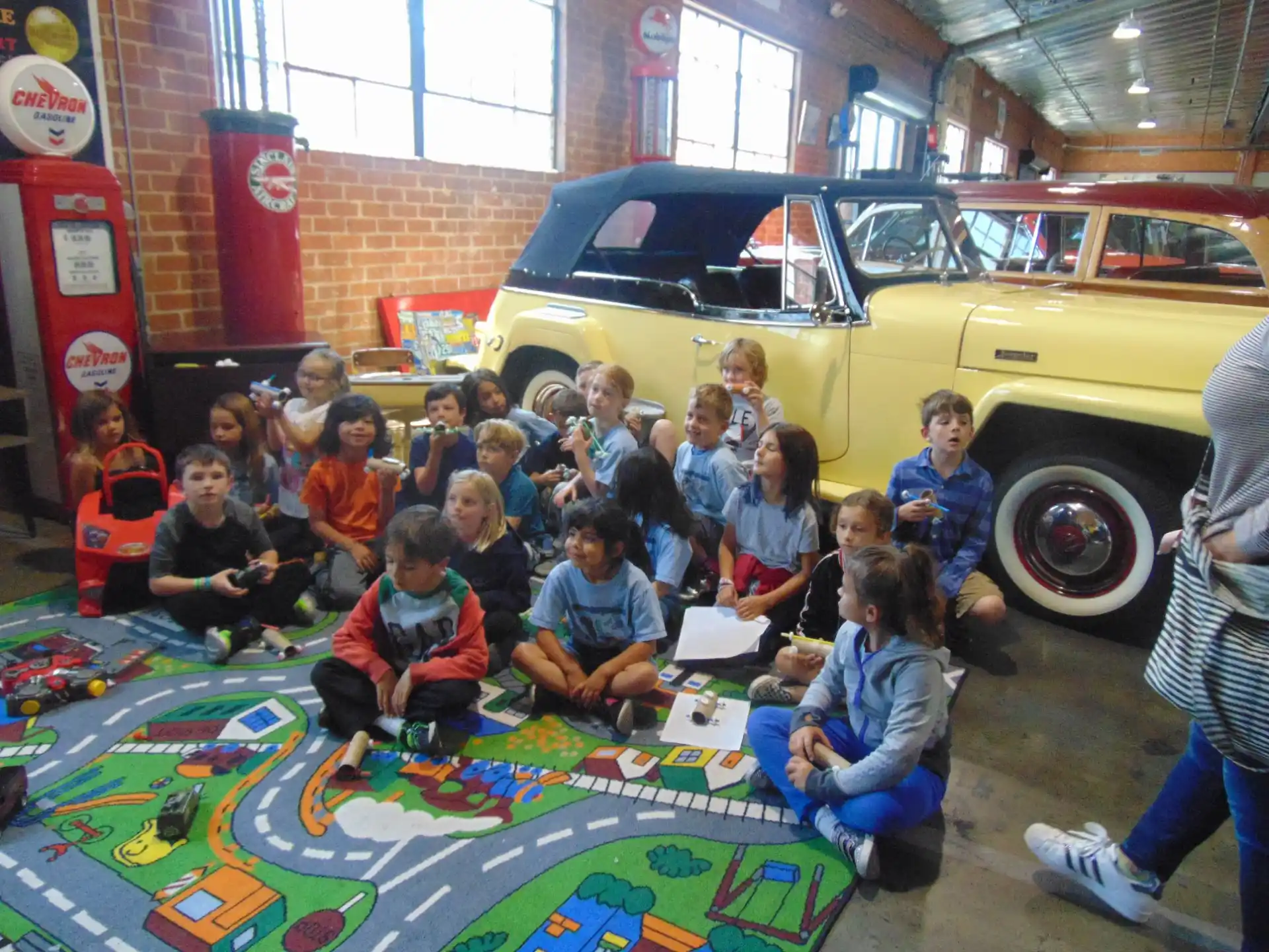 a group of children posing for a photo in front of a yellow truck