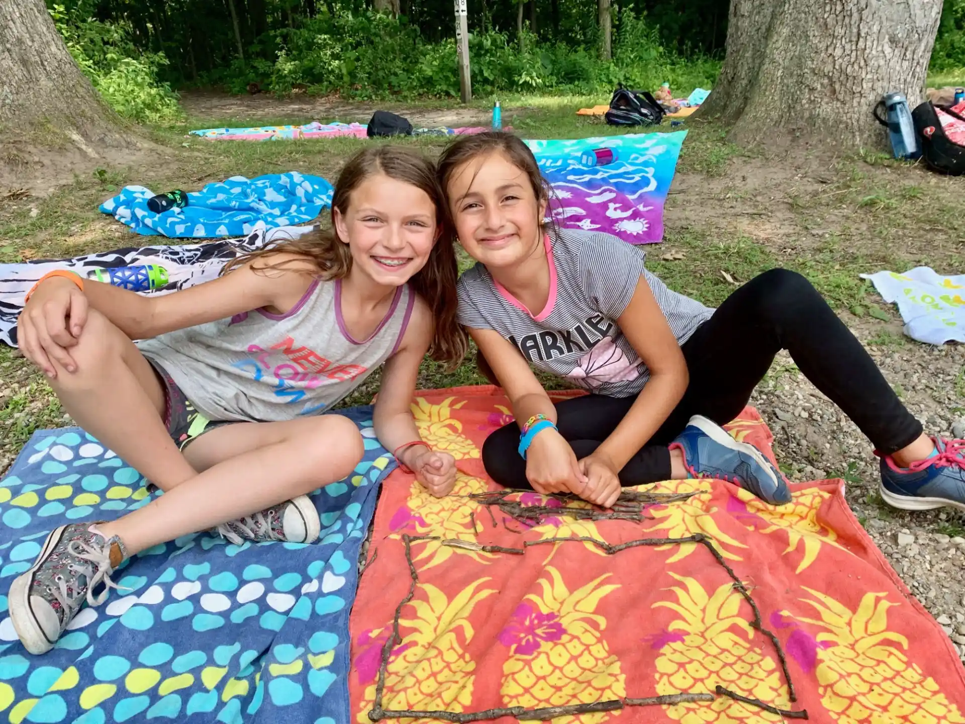 two girls sitting on a blanket