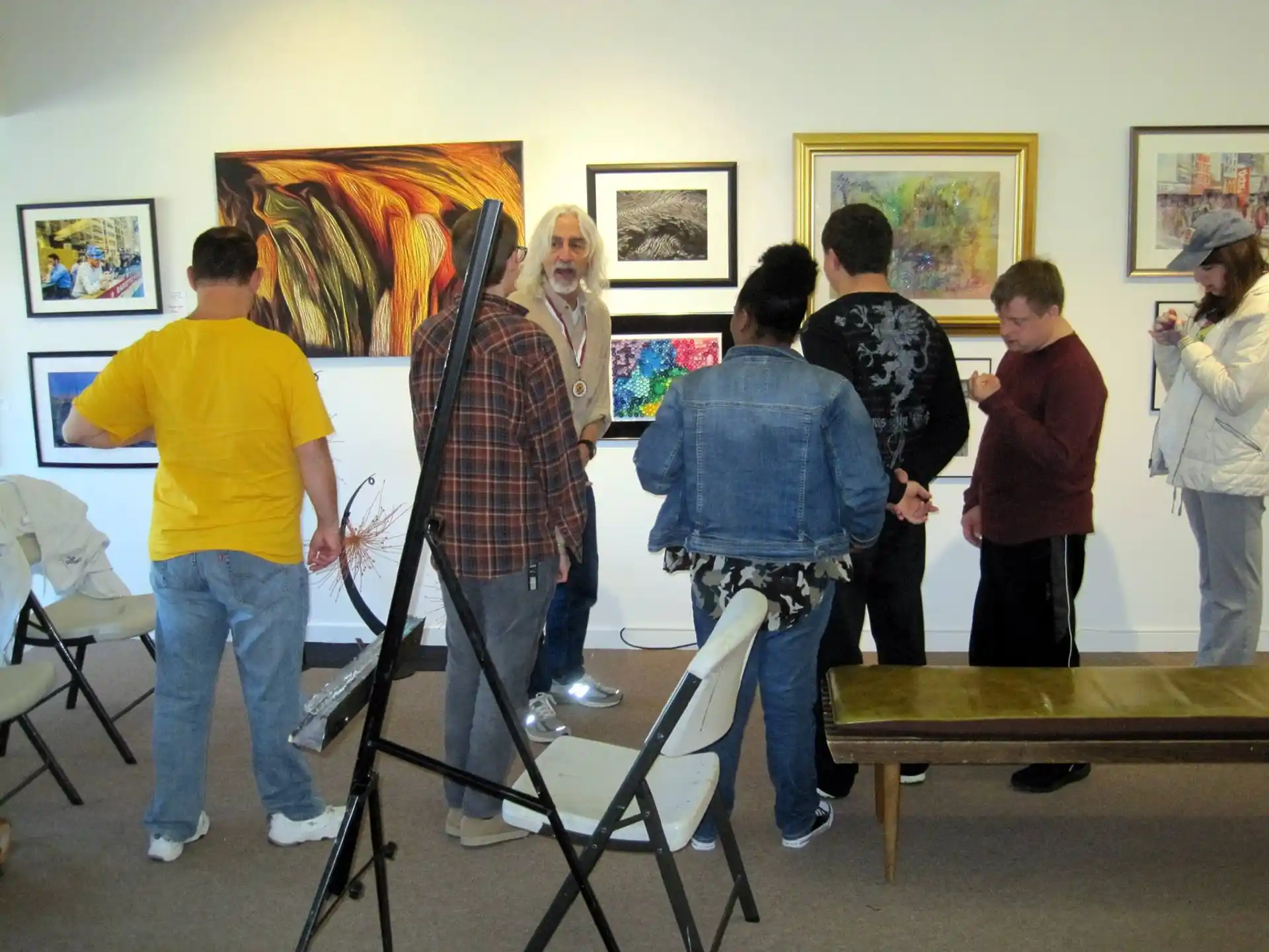 a group of people standing in a room with art on the wall