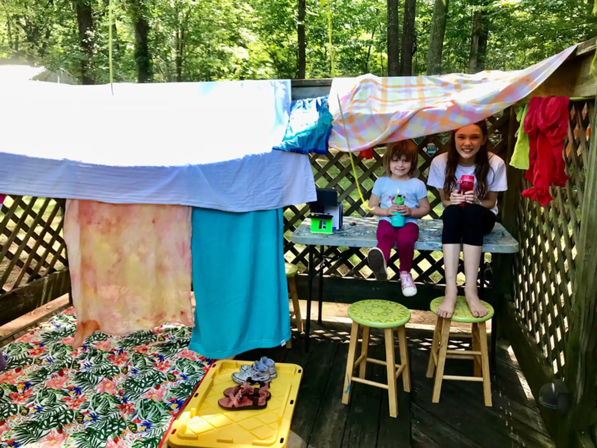 a group of girls sitting at a table under a tent