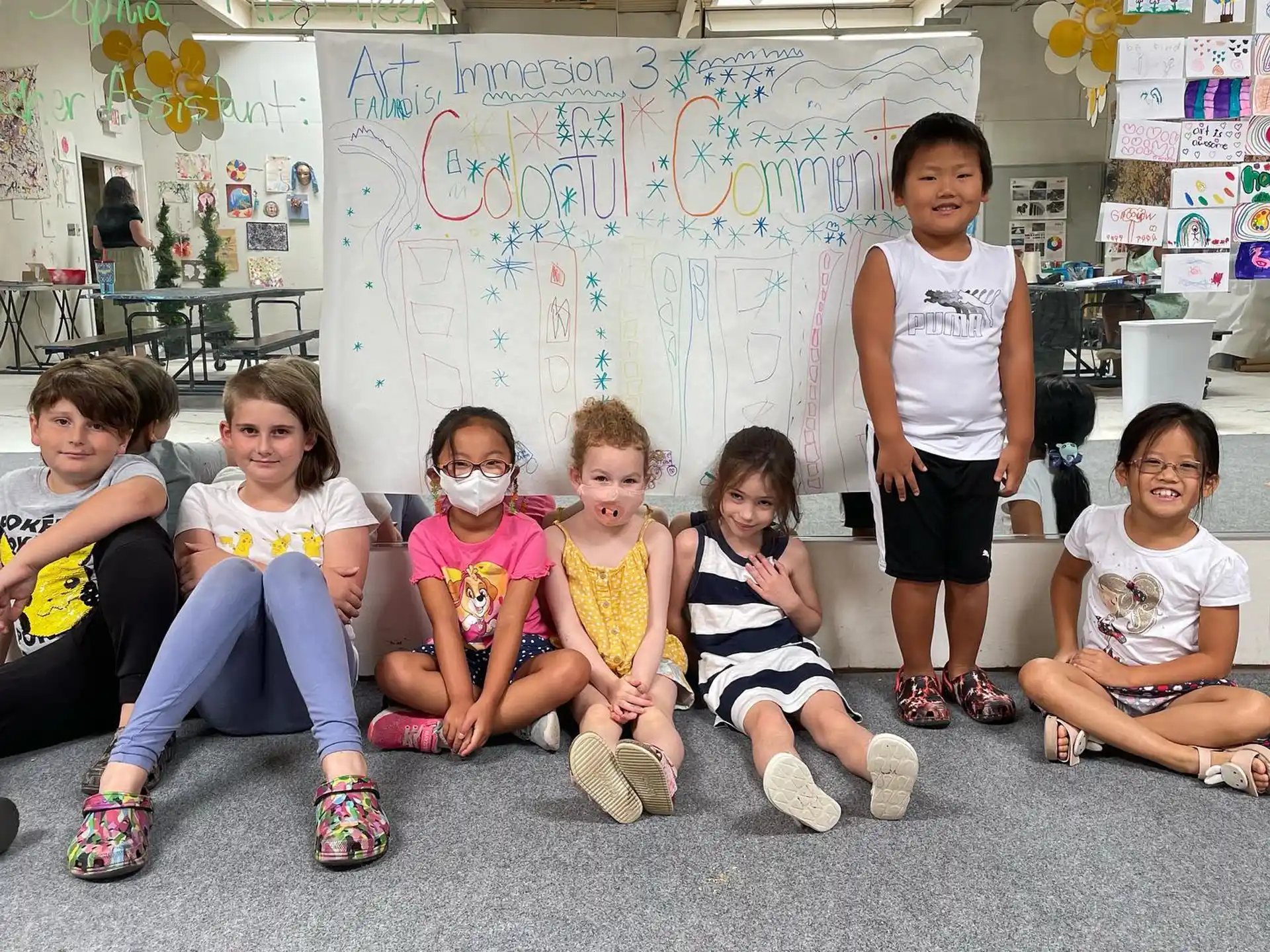 a group of children sitting on the floor in front of a wall