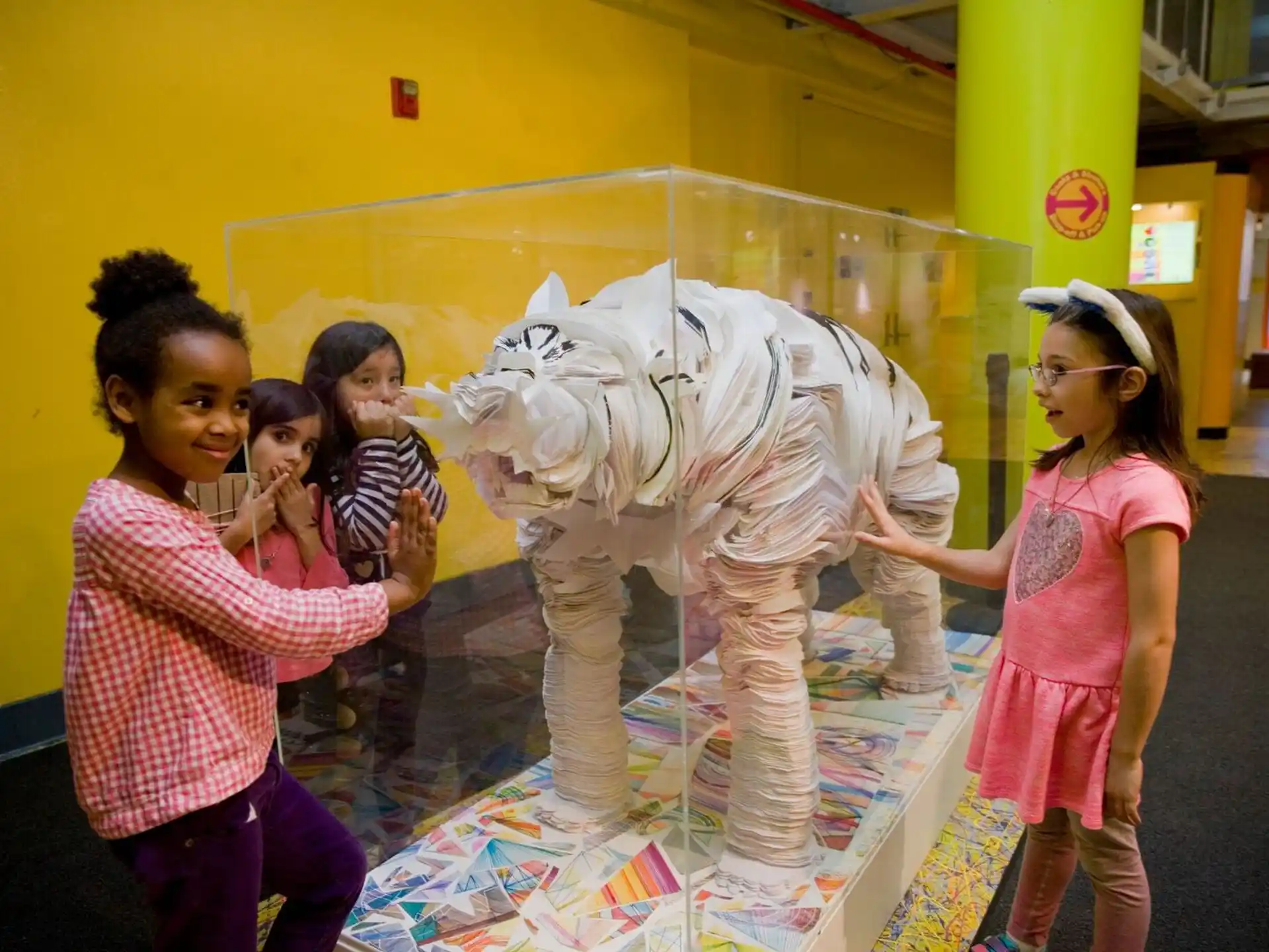 a group of children standing next to a statue of a person
