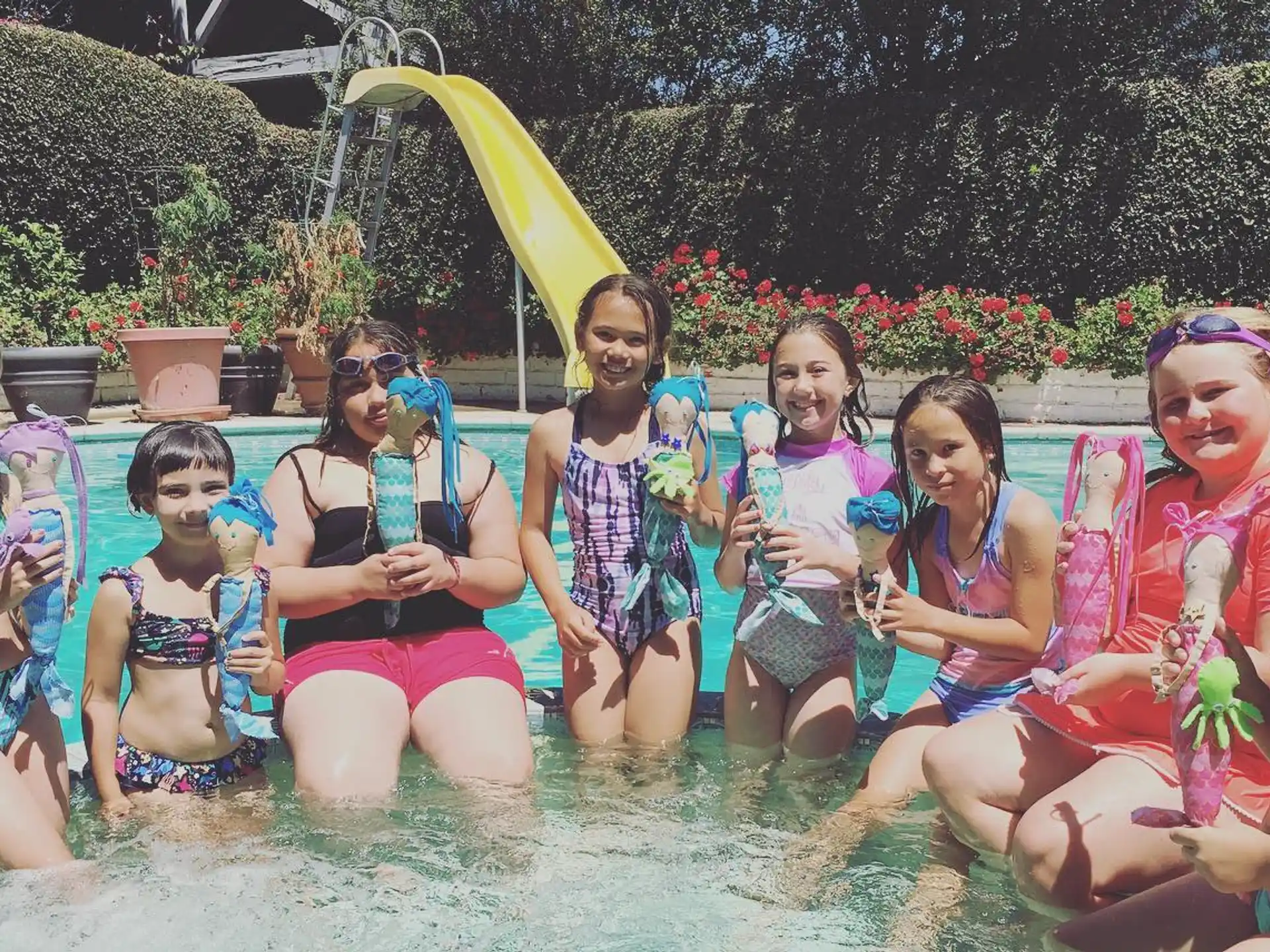 a group of girls in swimsuits in a pool
