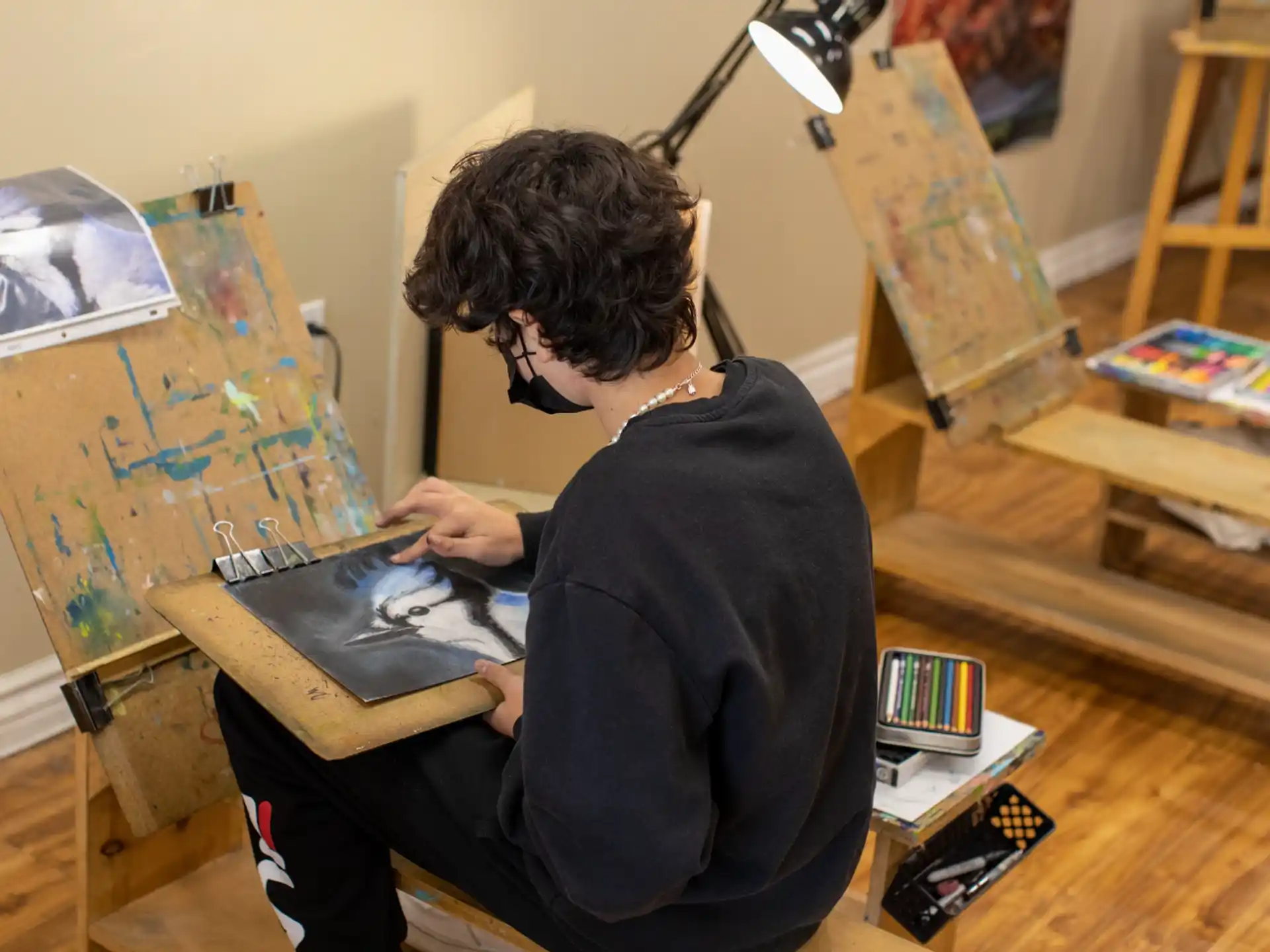 a man sitting on a chair with a laptop and a lamp