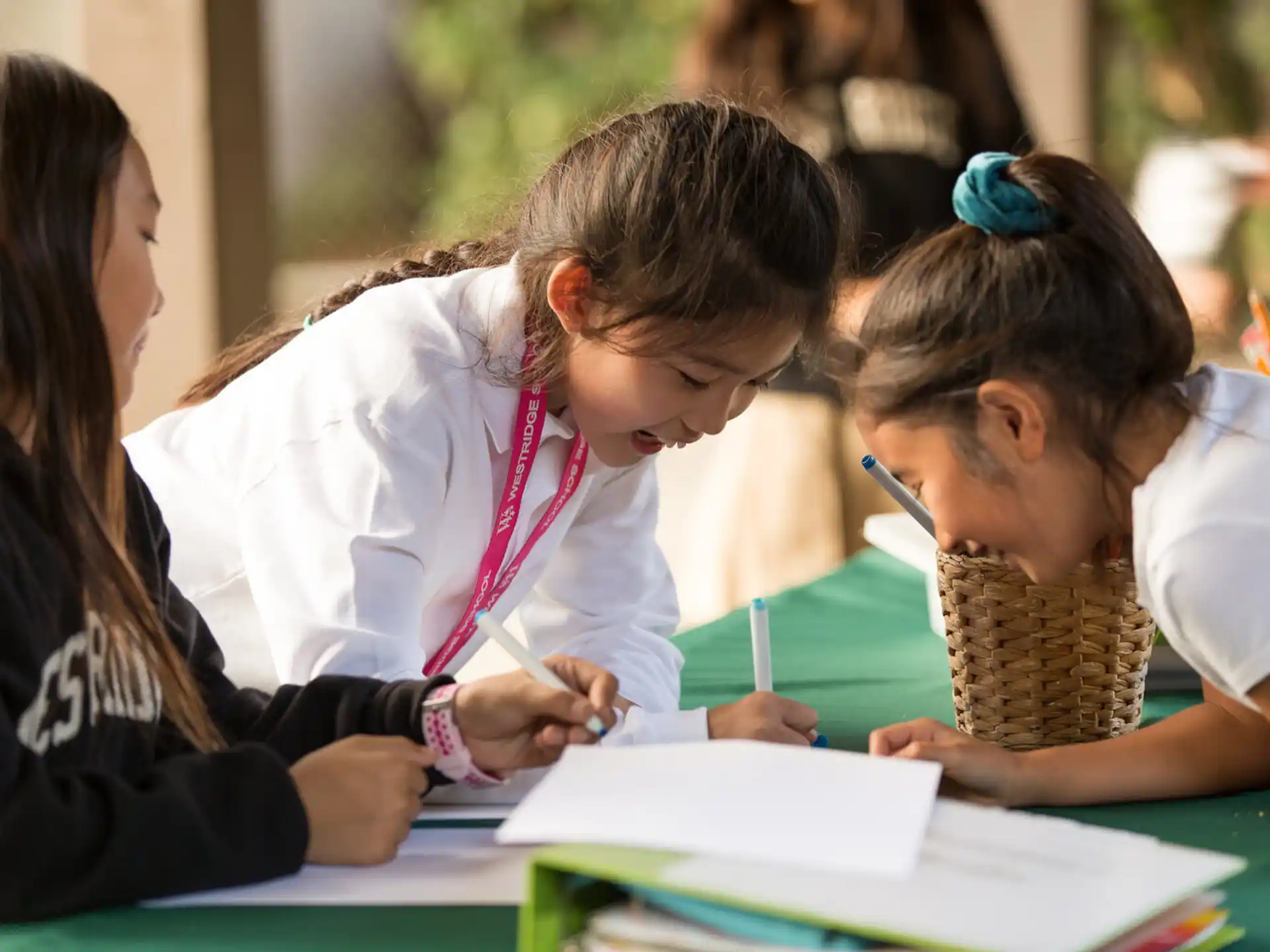 a group of children writing on a book