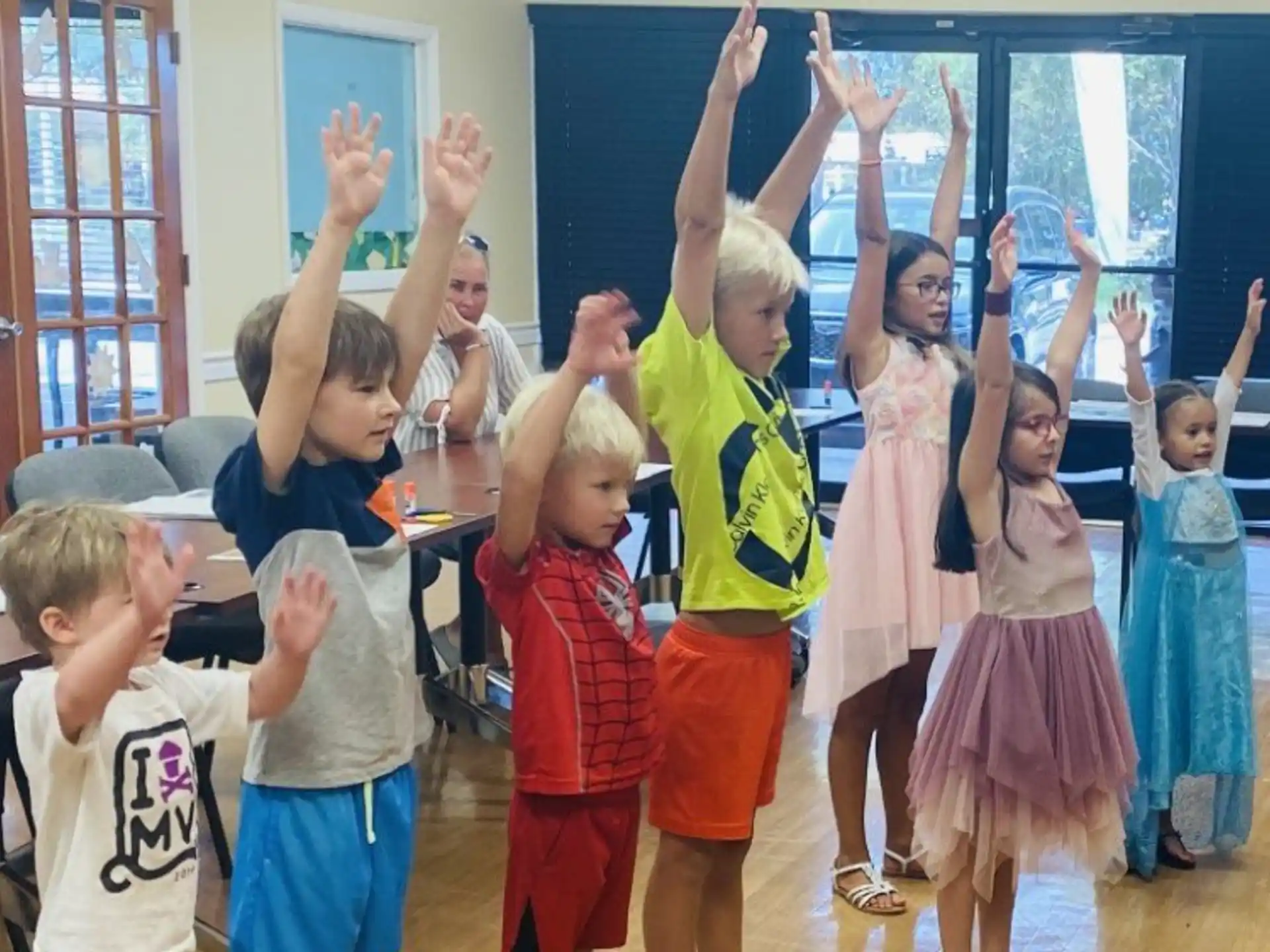 a group of children raising their hands