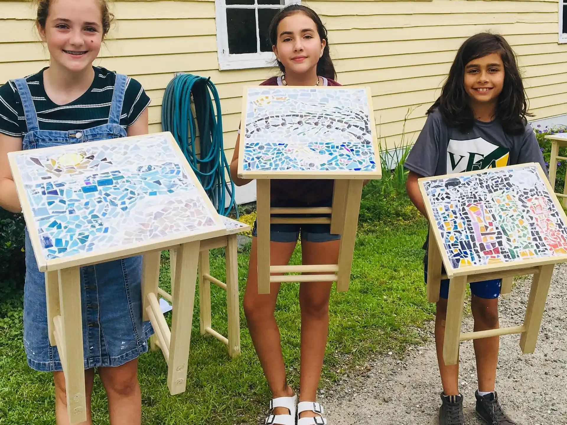 a group of girls holding up a table with a piece of paper