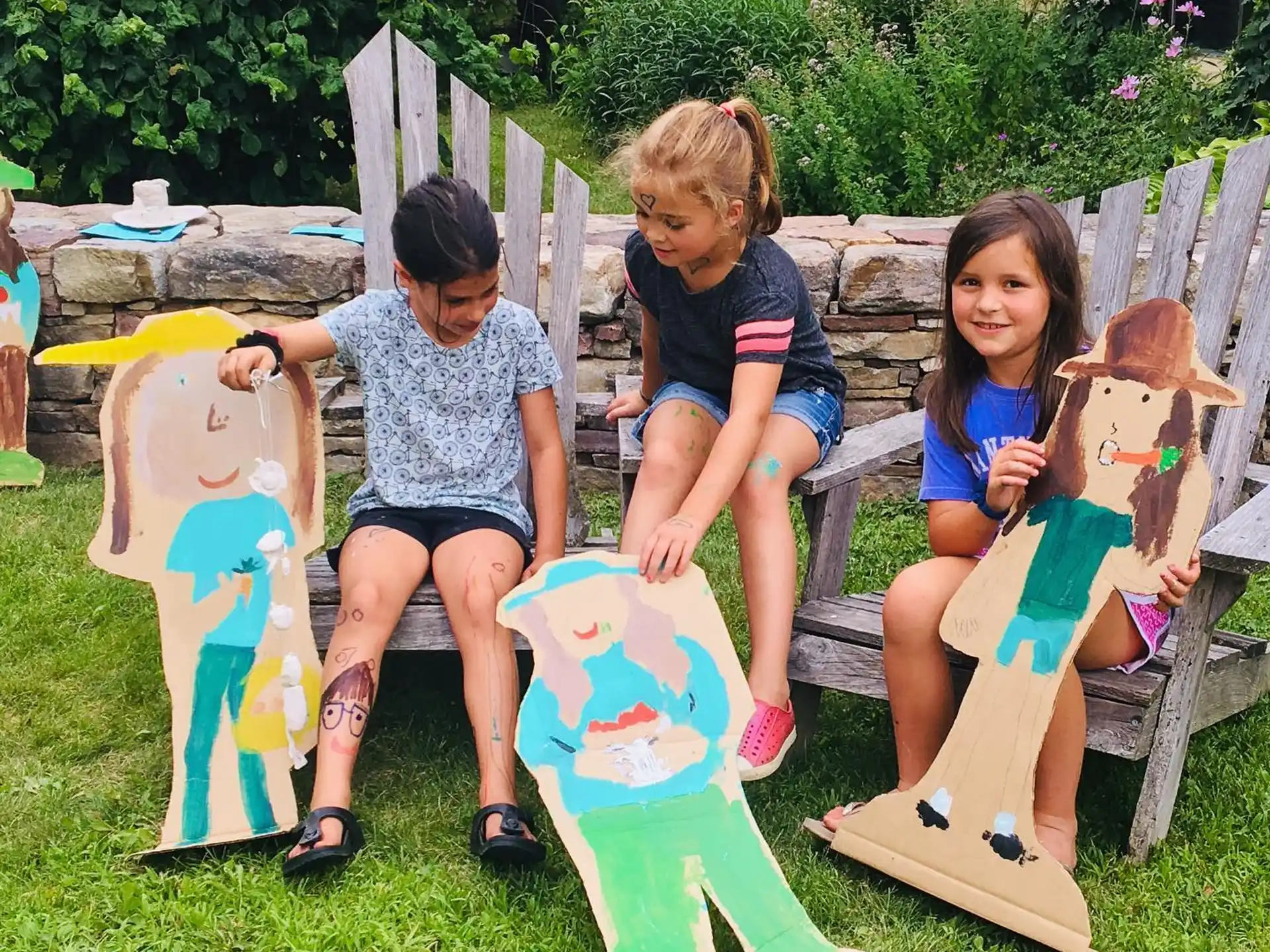 a group of girls sitting on a bench with their faces painted
