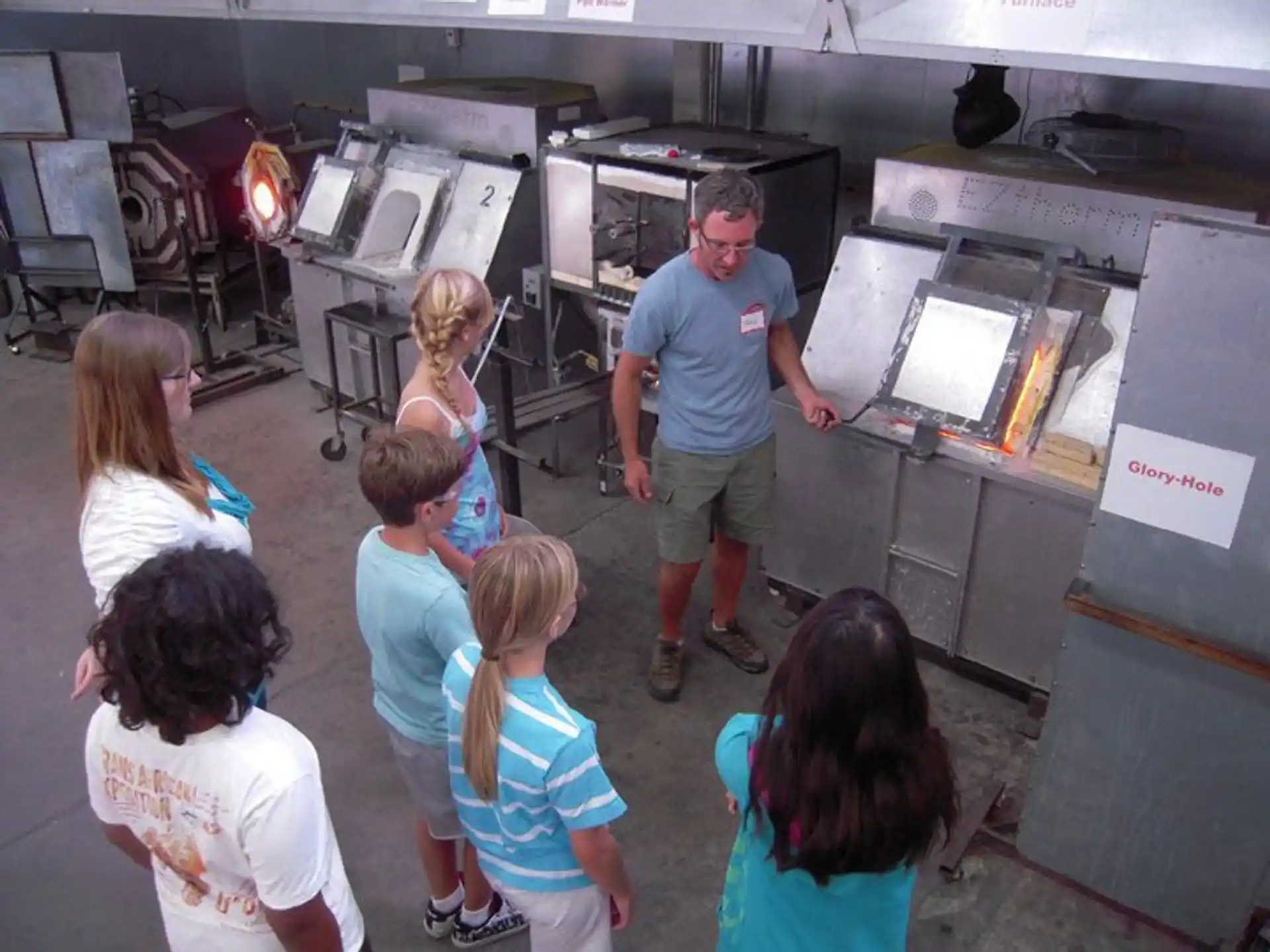 a person and a group of children looking at a machine