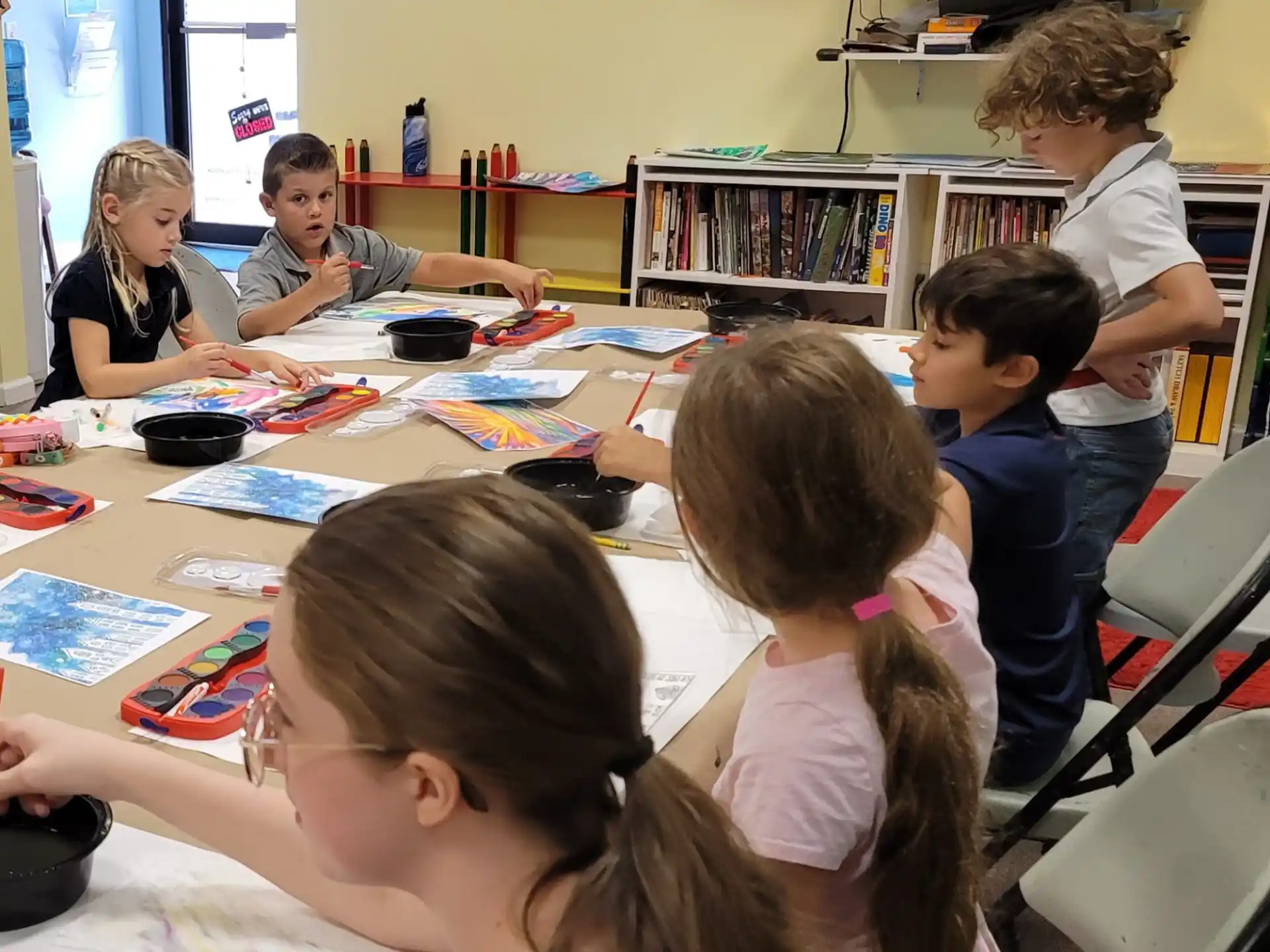 a group of children sitting around a table