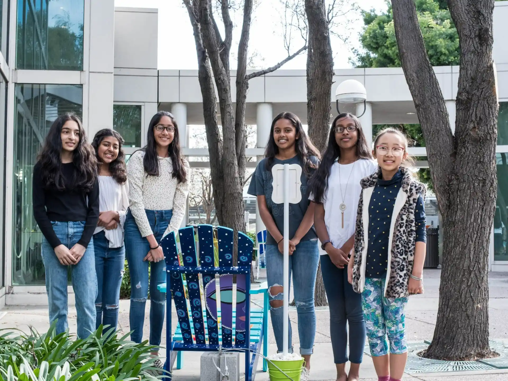 a group of women posing for a photo outside a building