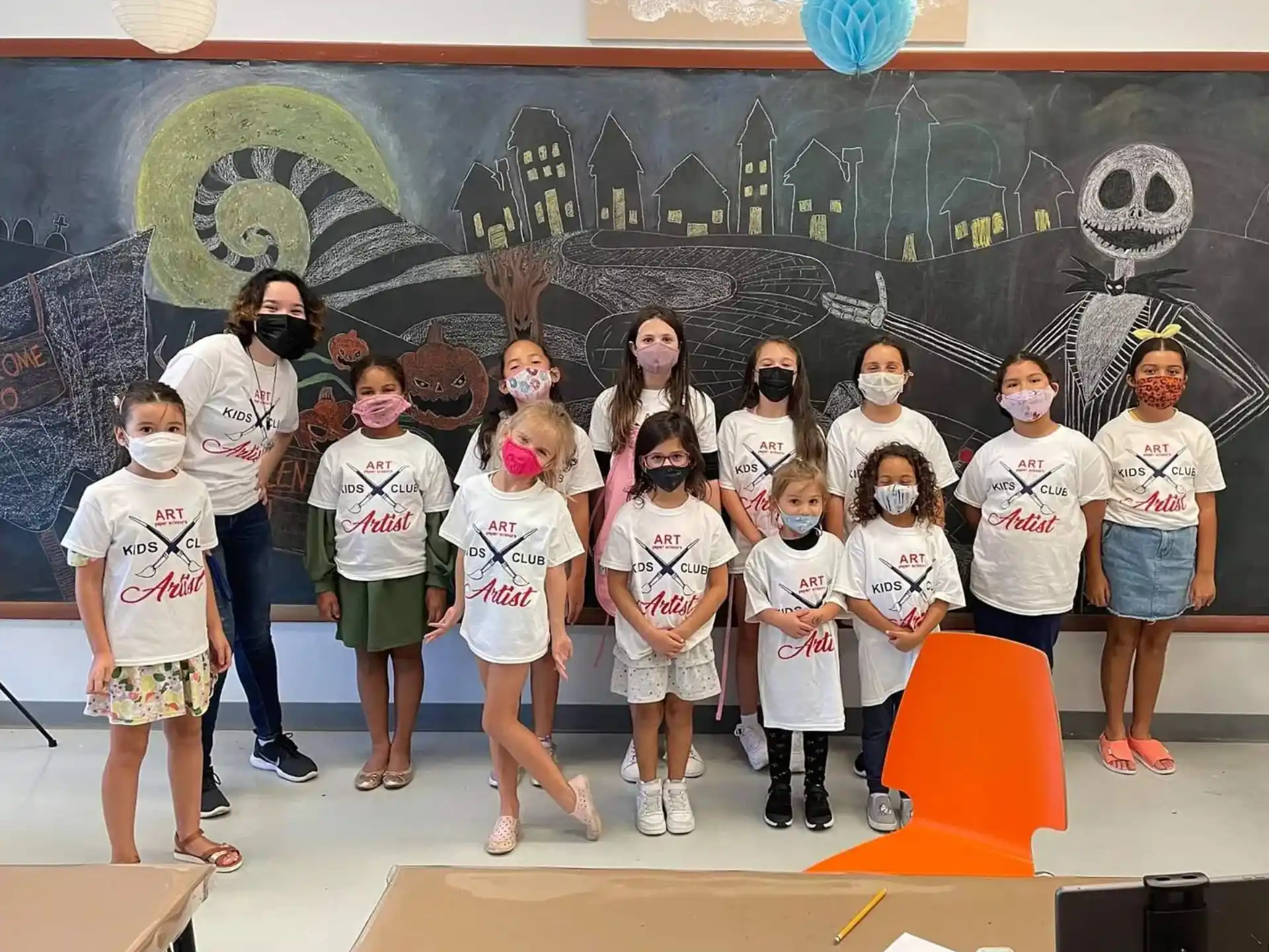 a group of children in front of a chalkboard