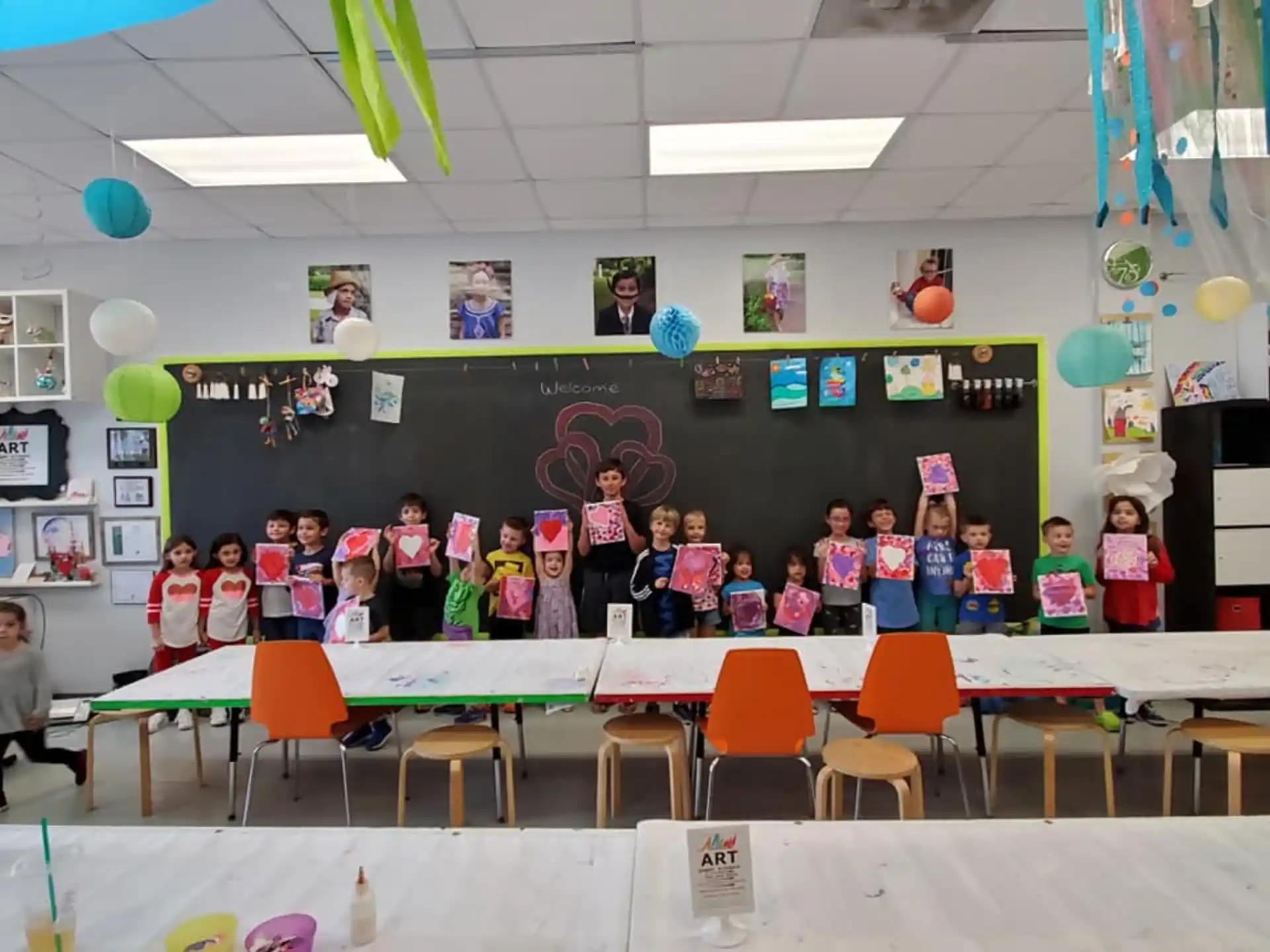 a group of children posing for a photo in front of a chalkboard