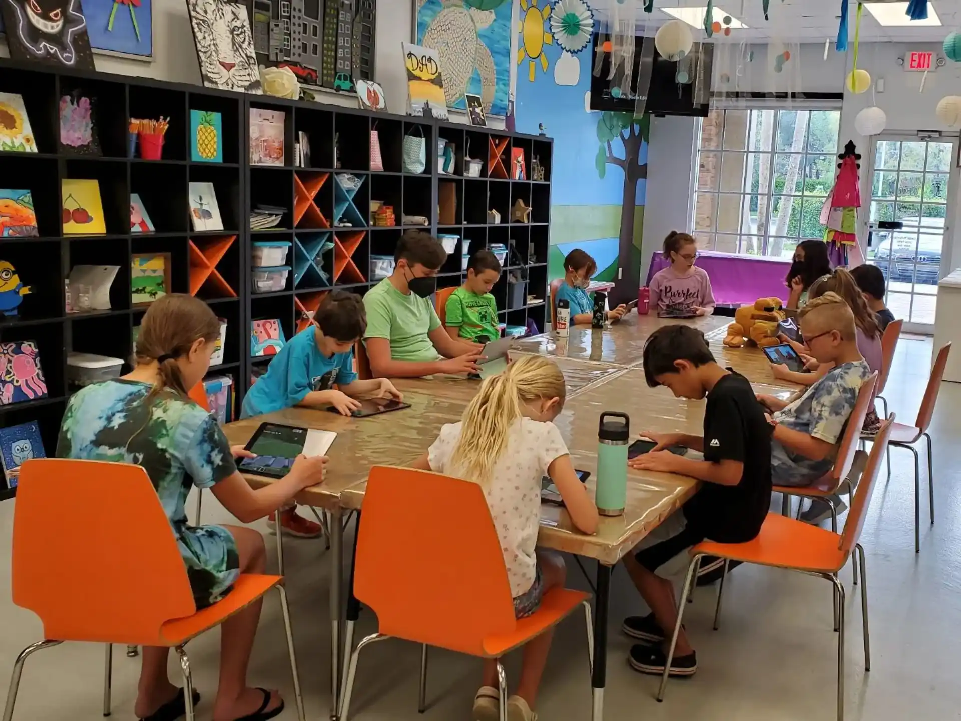 a group of children sitting at a table in a library