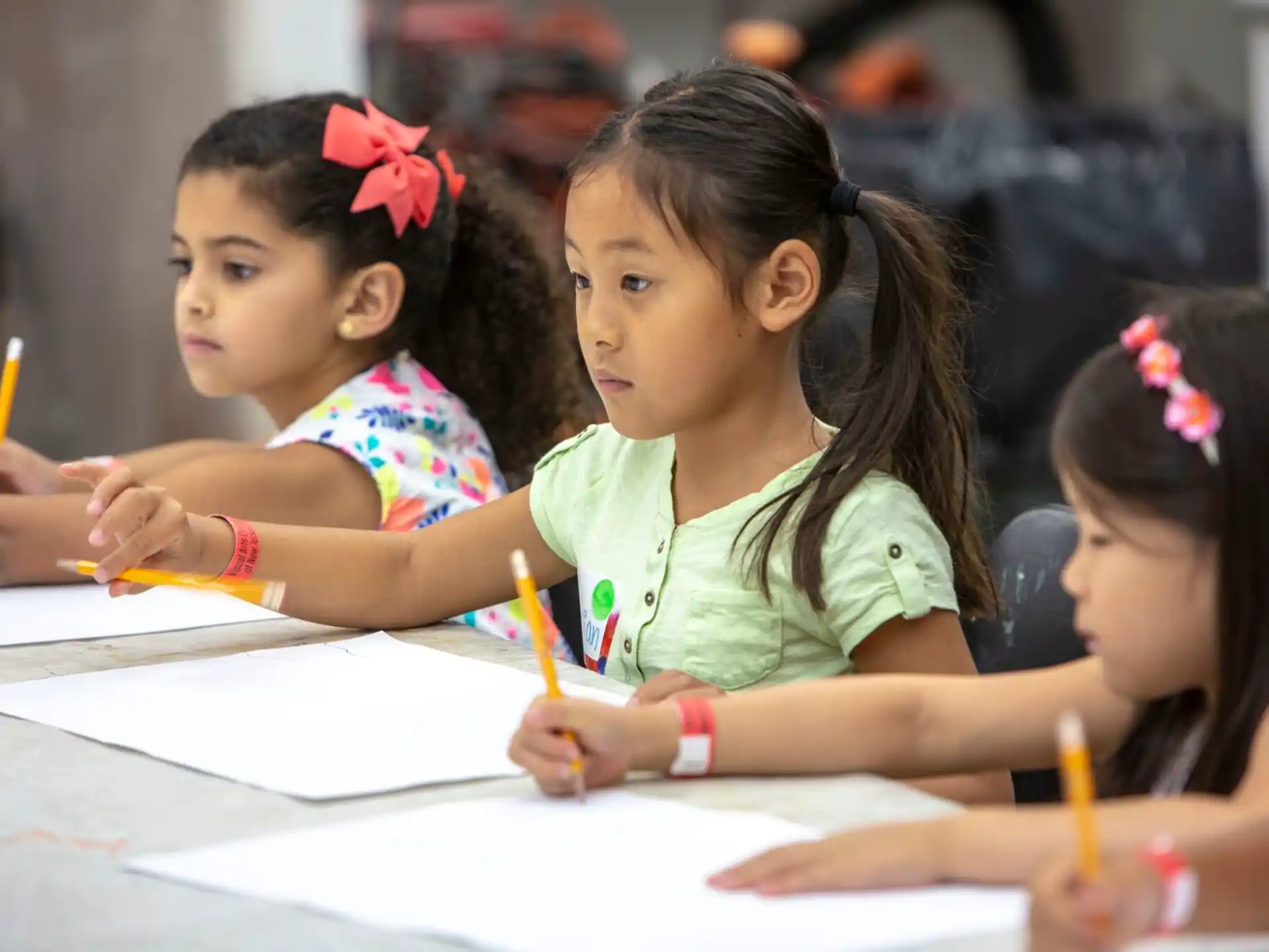 a group of young girls writing on paper