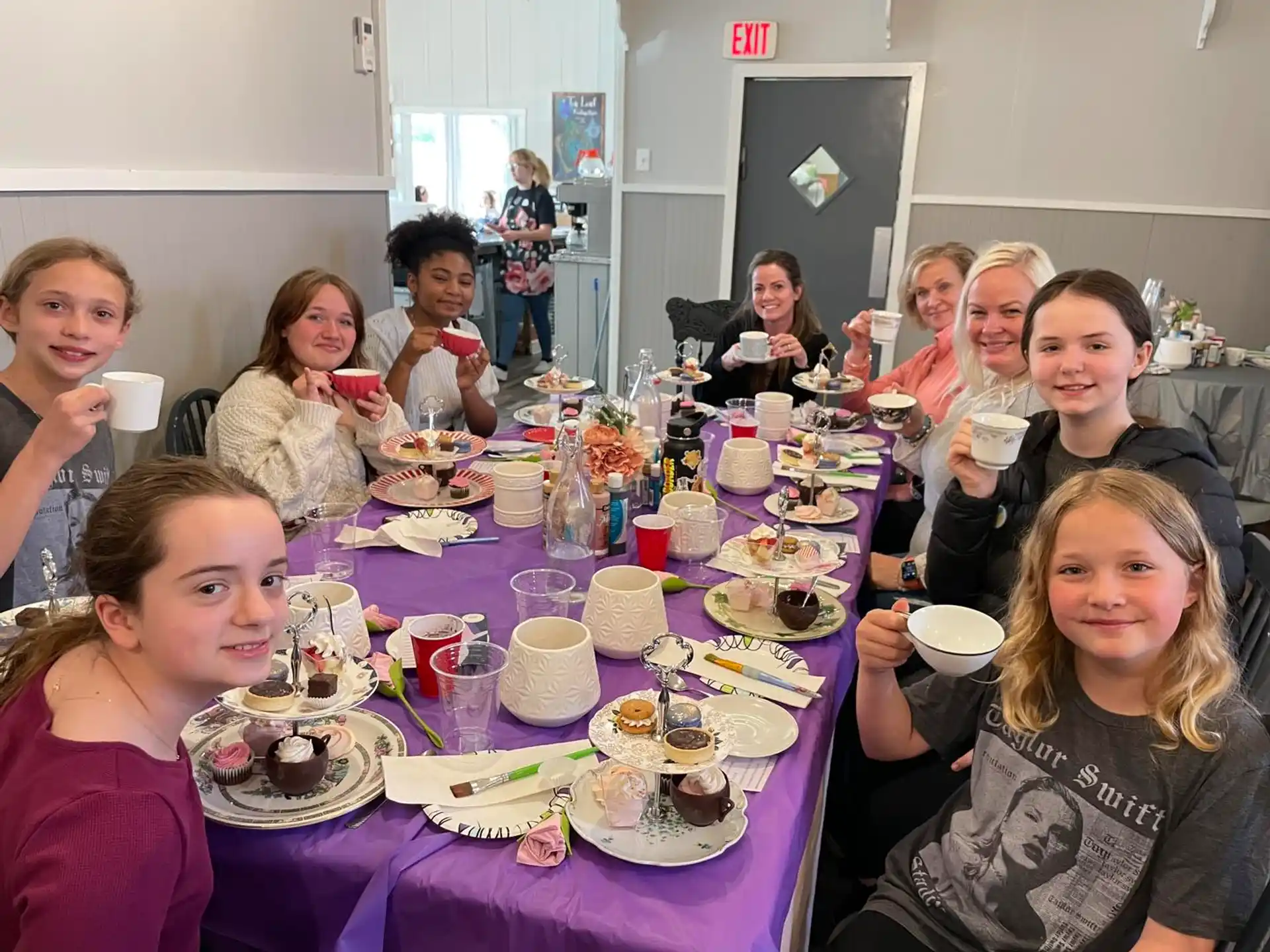 a group of people sitting at a table with food