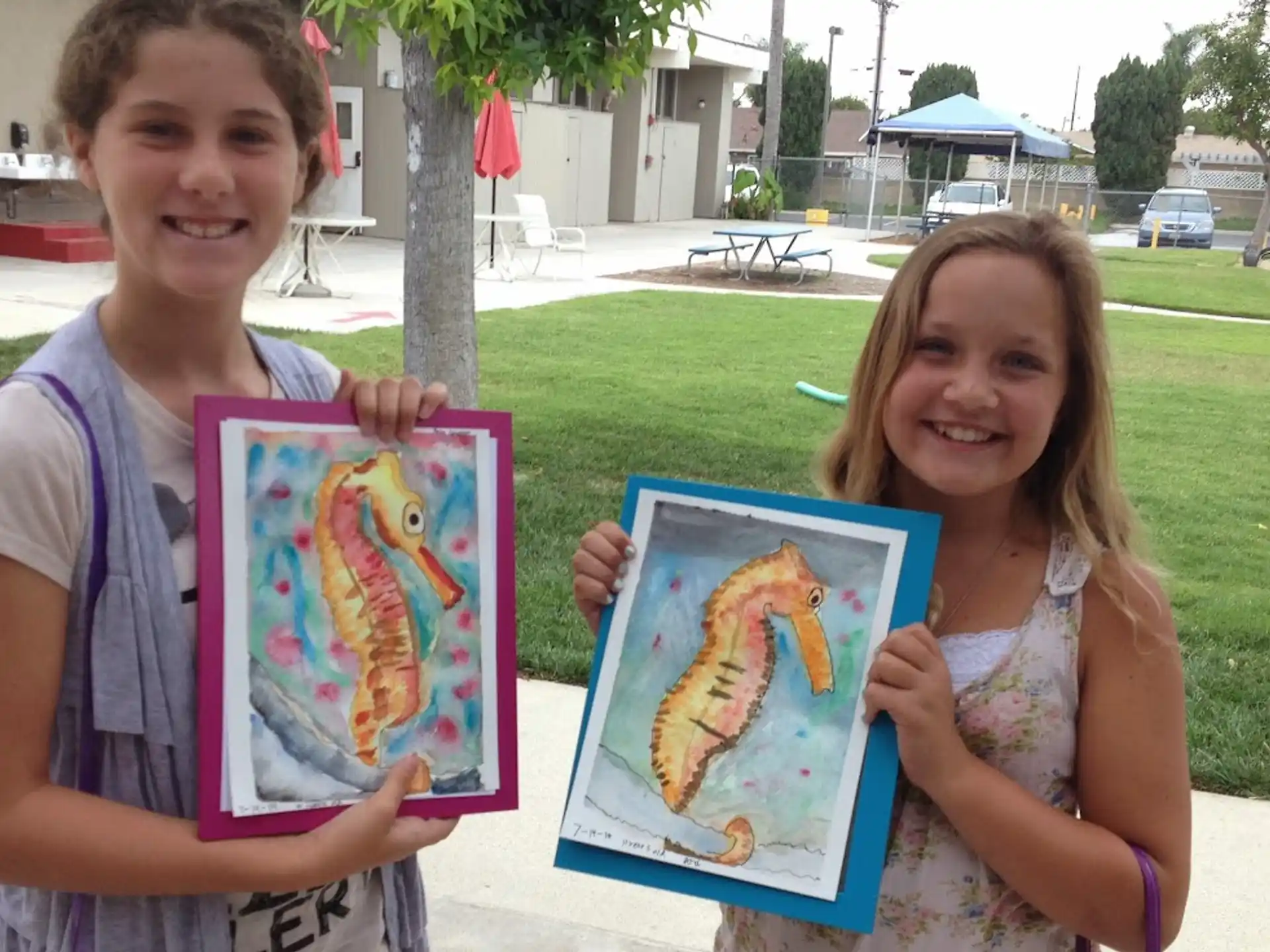 a boy and girl holding up a picture of a girl