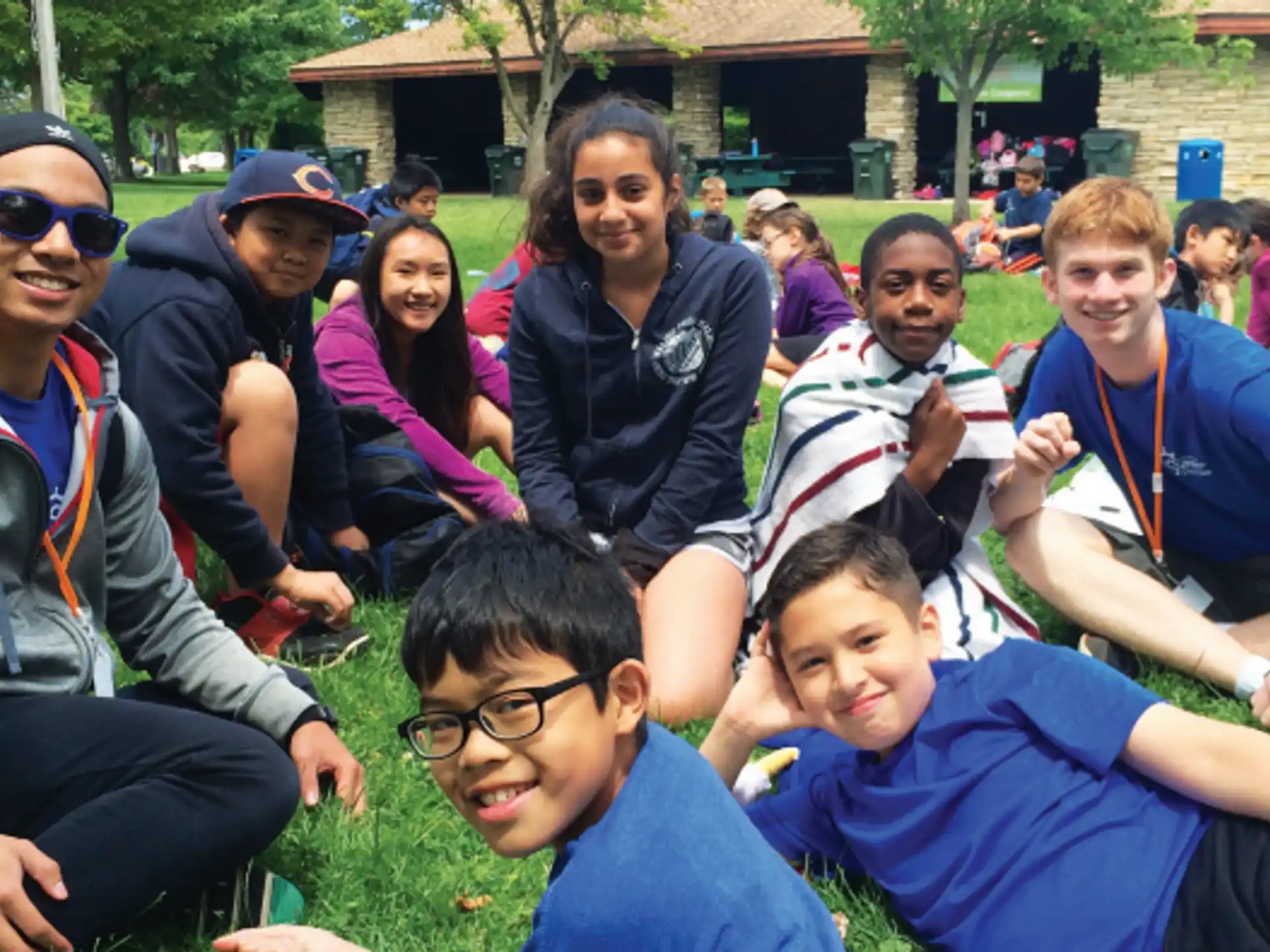 a group of people sitting on the grass