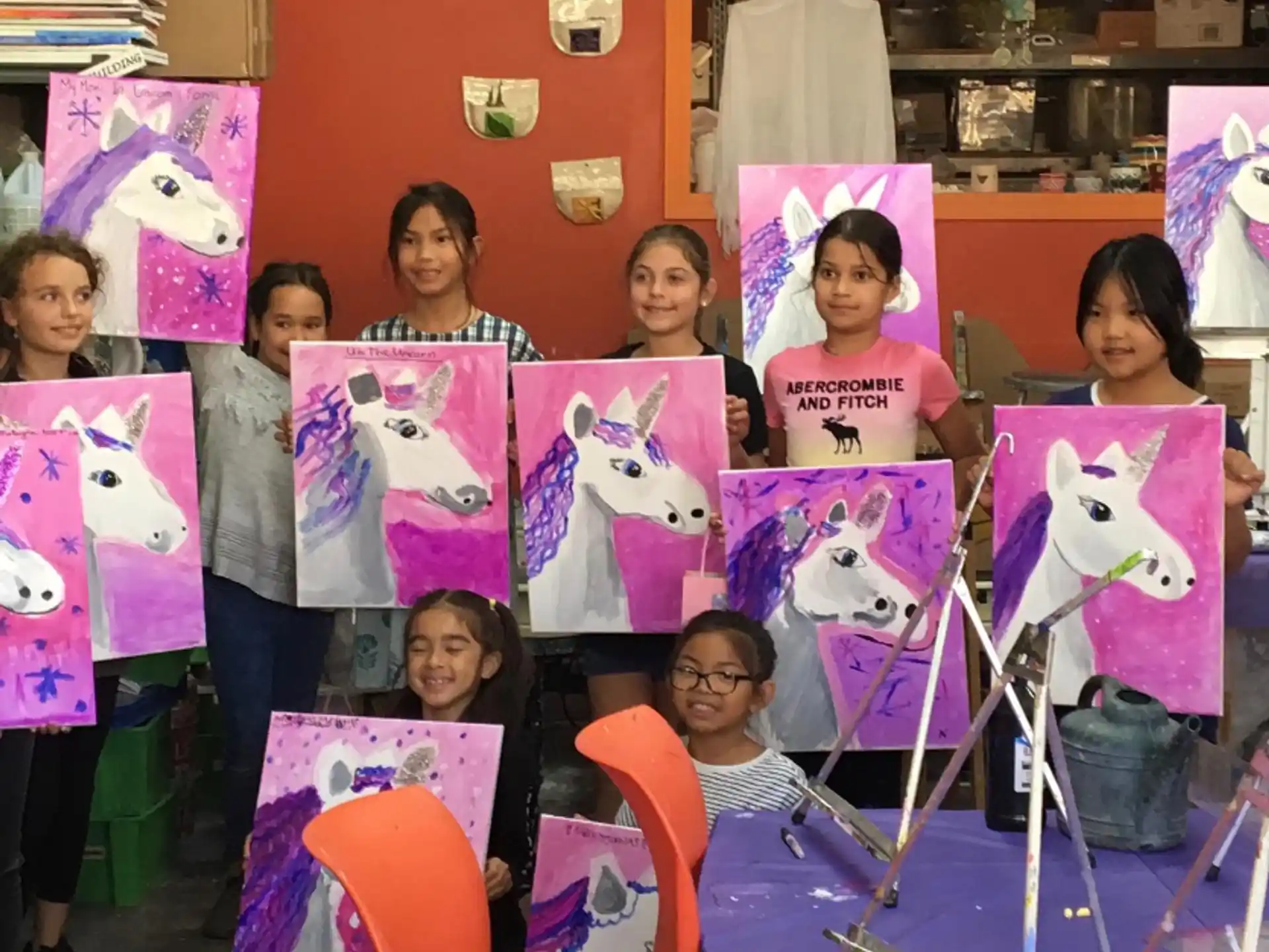 a group of children holding up pink and white paper signs