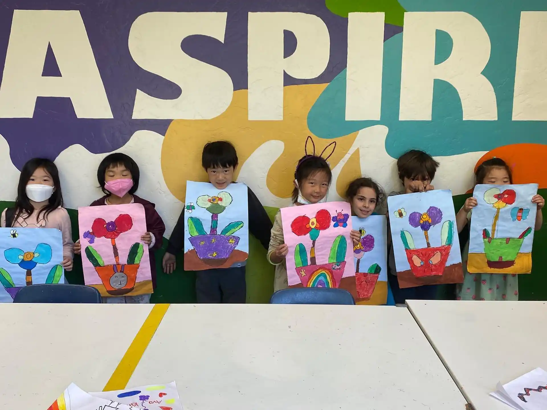 a group of children holding up colorful boxes