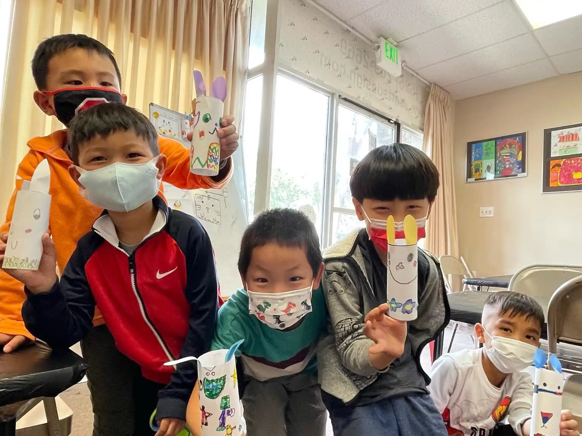 a group of kids holding up paper bags