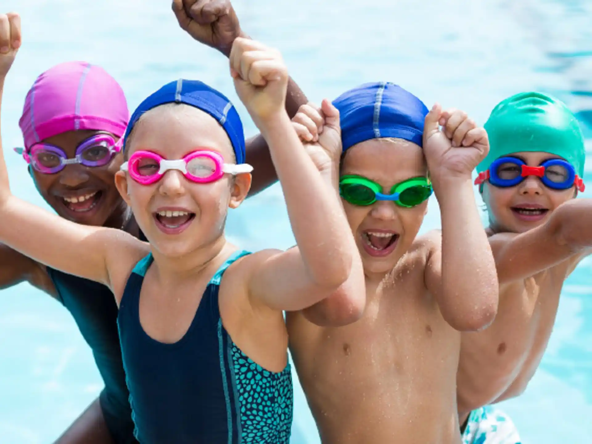 a group of kids wearing goggles and swimming in a pool
