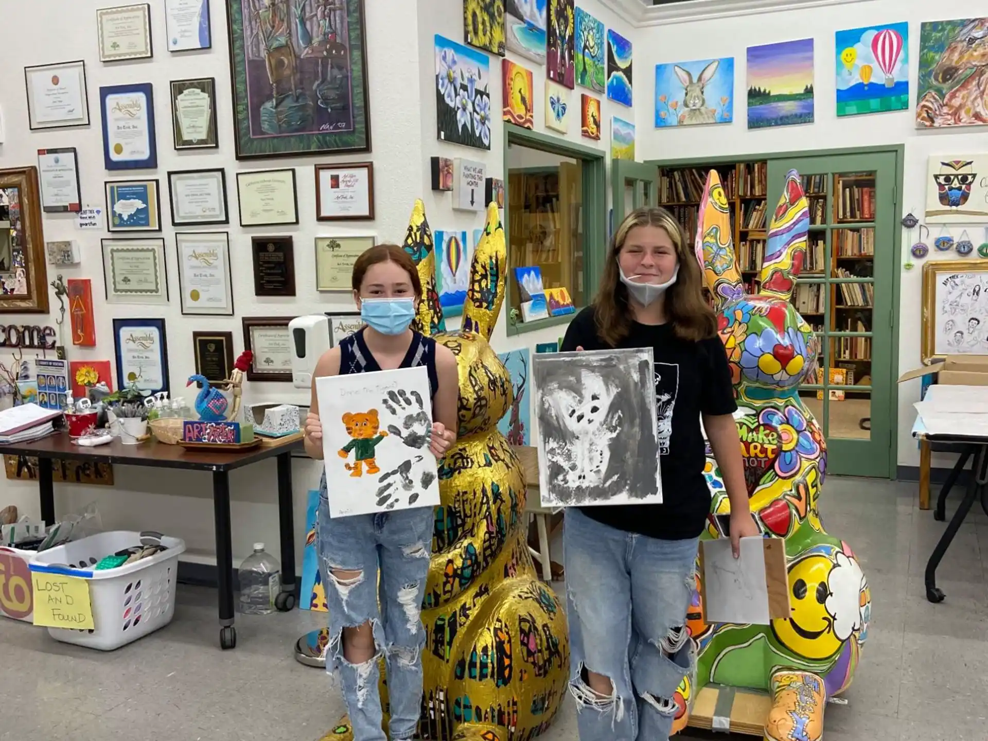 a person and a boy wearing face masks in a room with posters