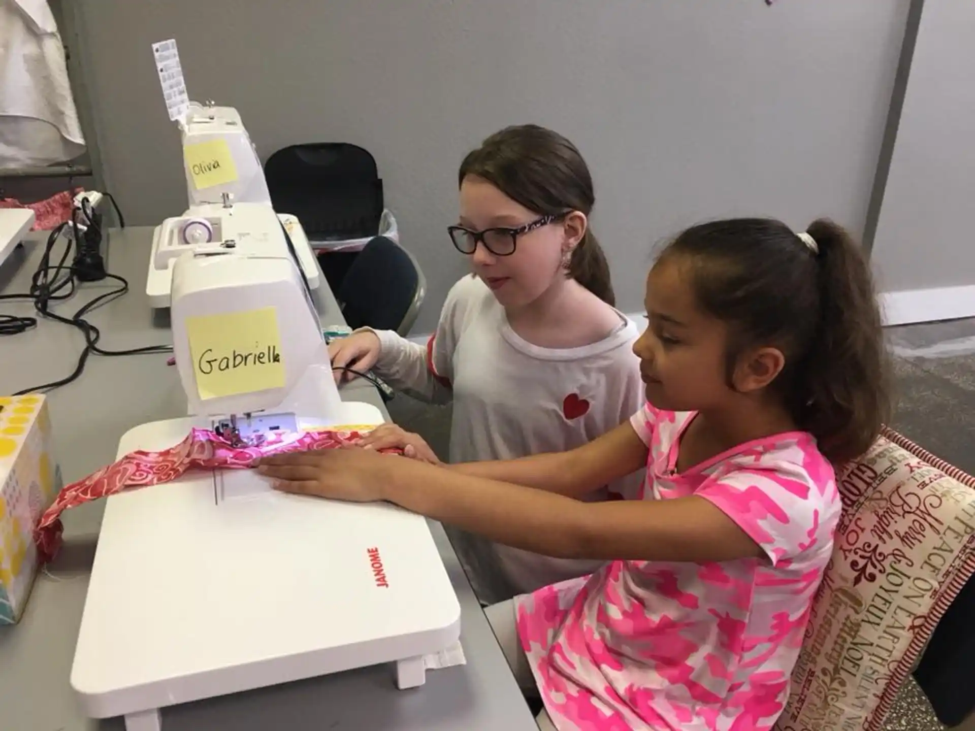 a person and a girl looking at a sewing machine