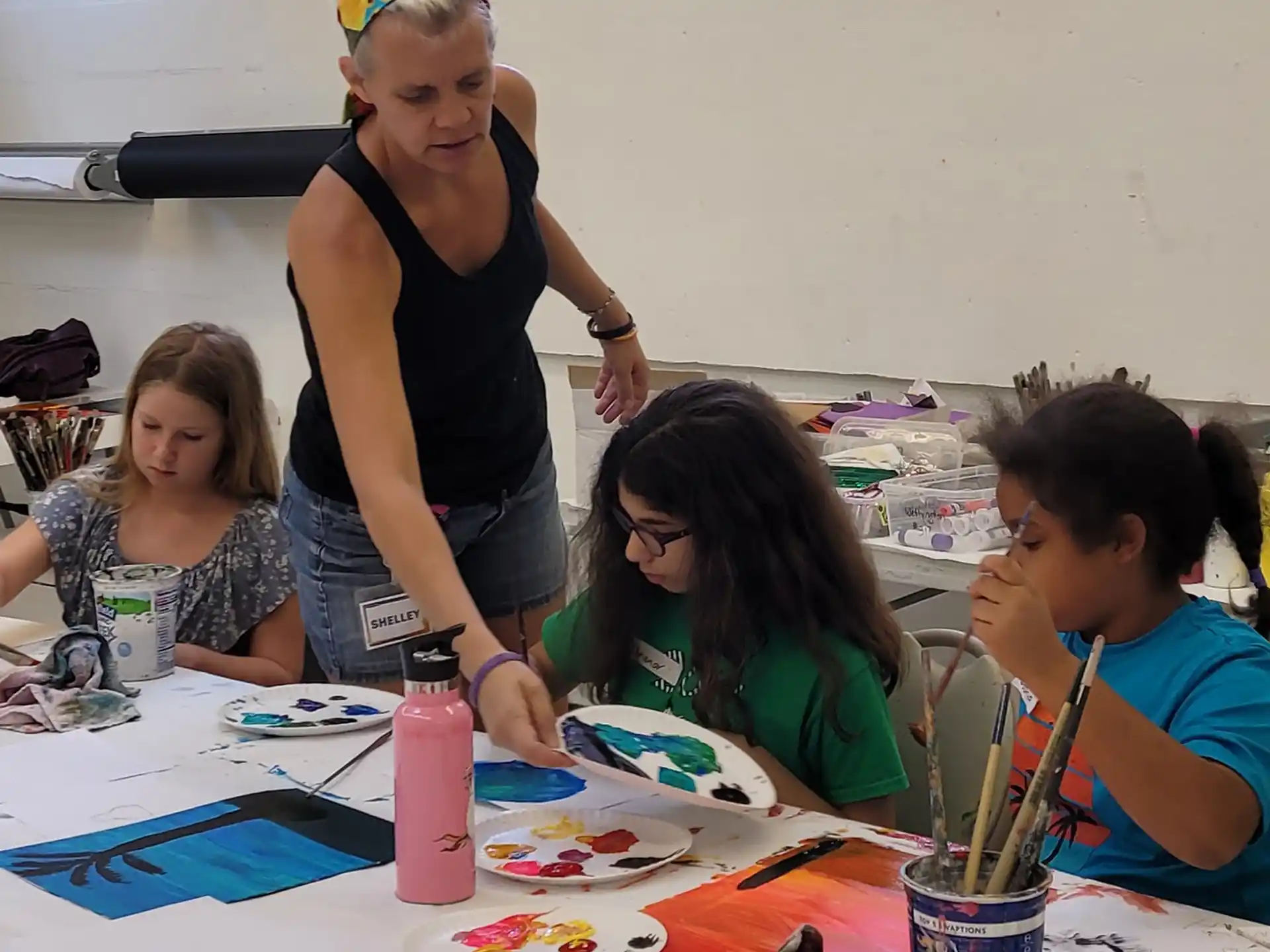a person and several children painting