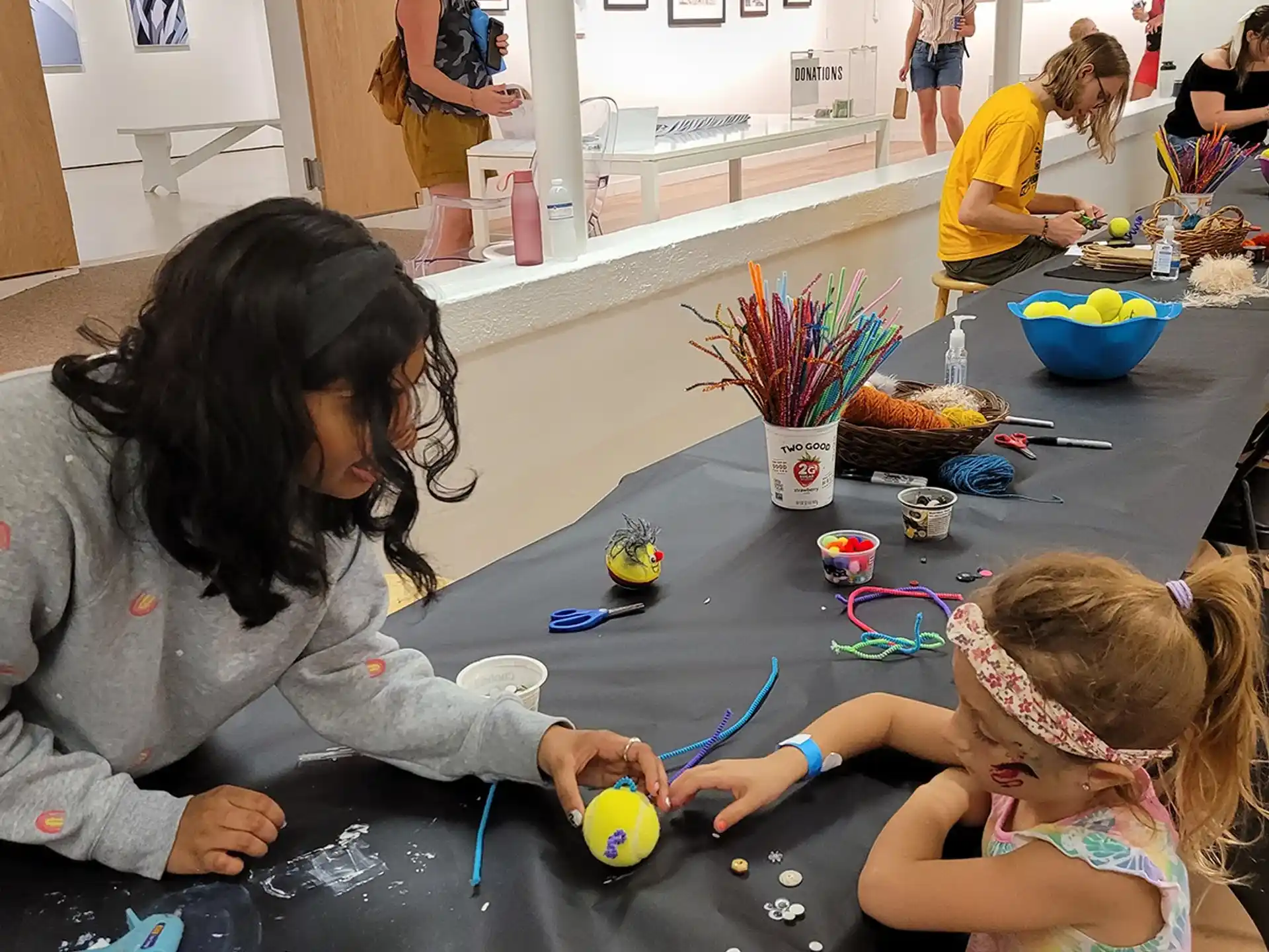 a woman and a child playing with toys on a table