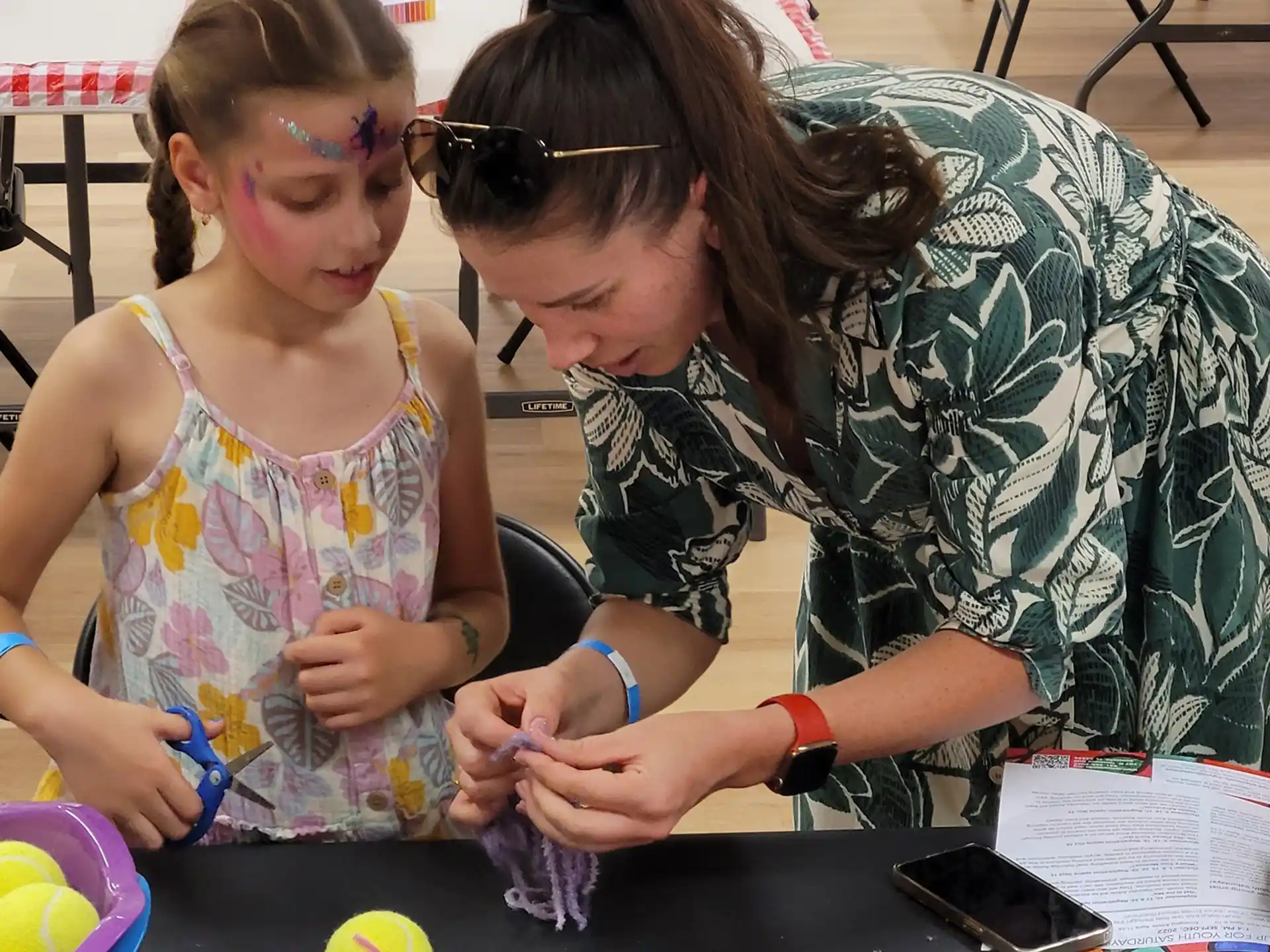 a woman and a girl playing with a toy
