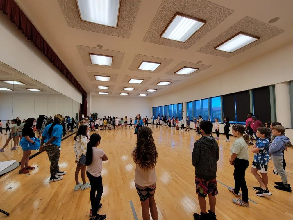 a group of people dancing in a room with blue walls