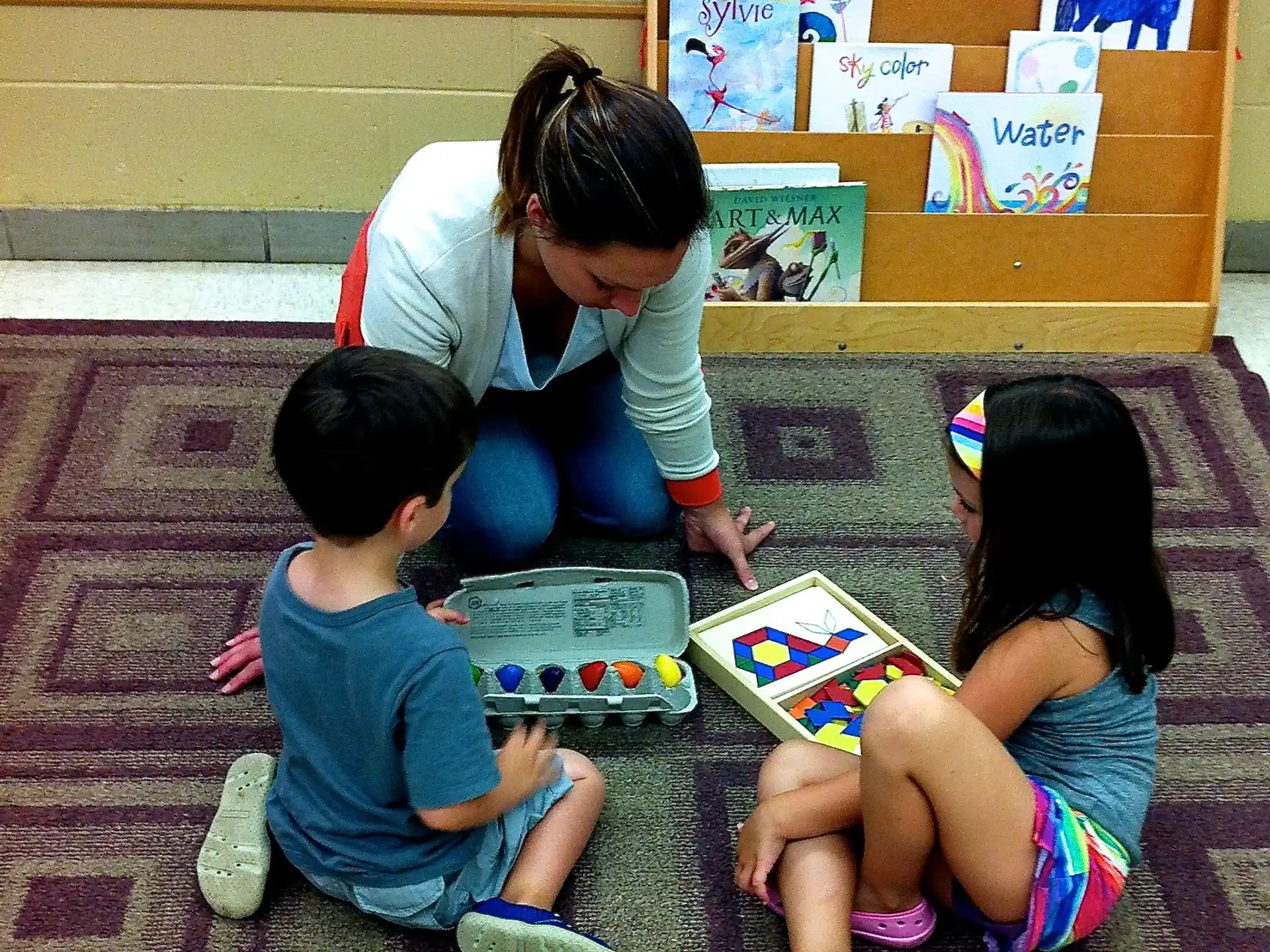 a person and two children reading a book