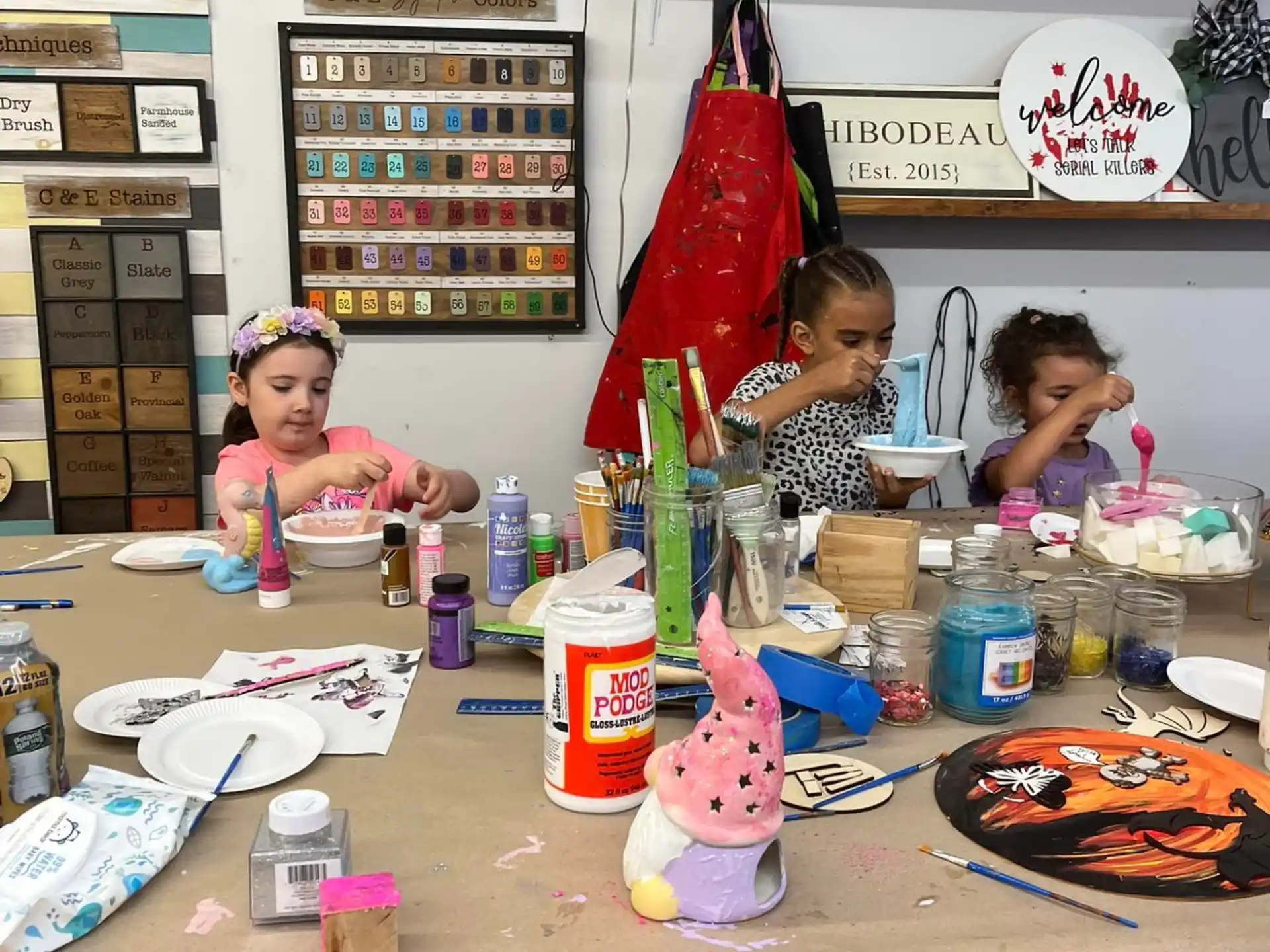 a group of kids sitting at a table with food and drinks