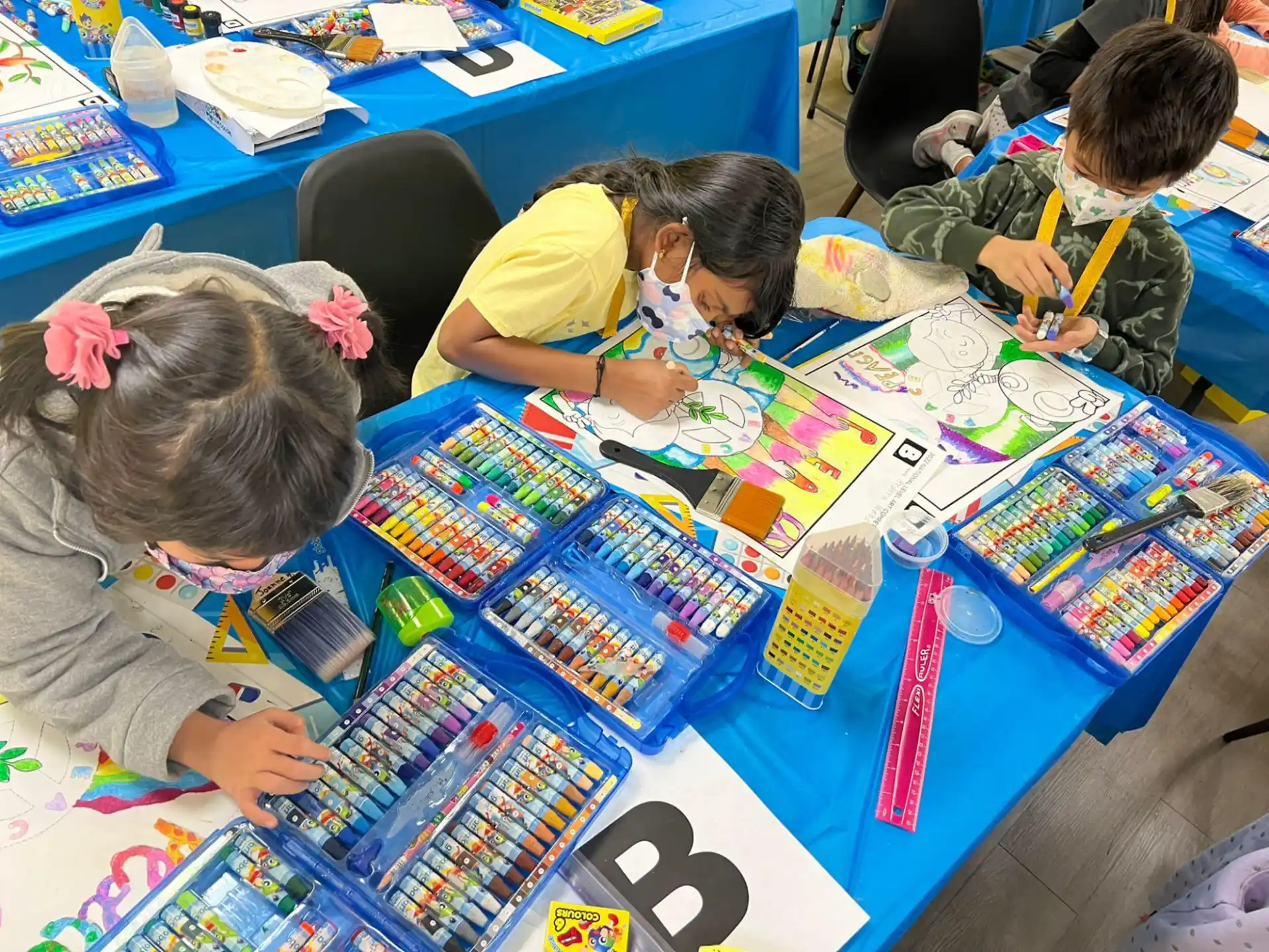 children sitting at a table with colorful books