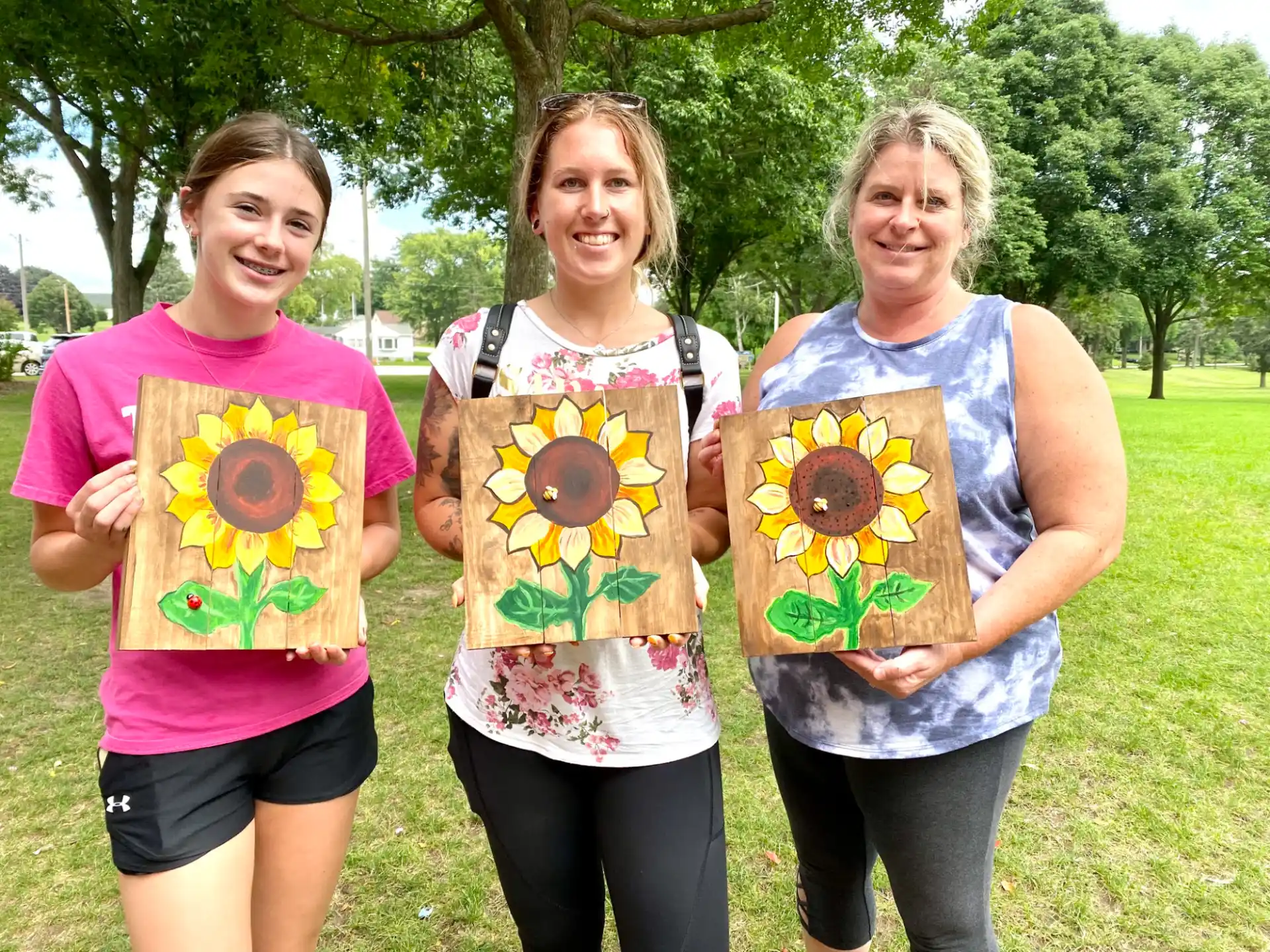 a group of women holding paintings
