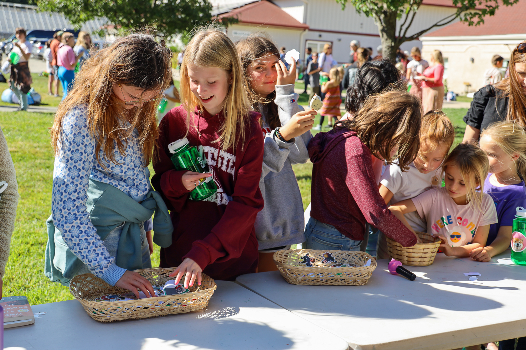 a group of children sitting at a table with baskets of food