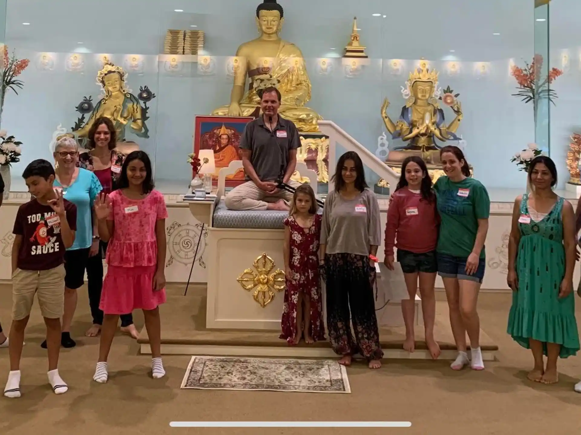 a group of people posing for a photo in front of a statue