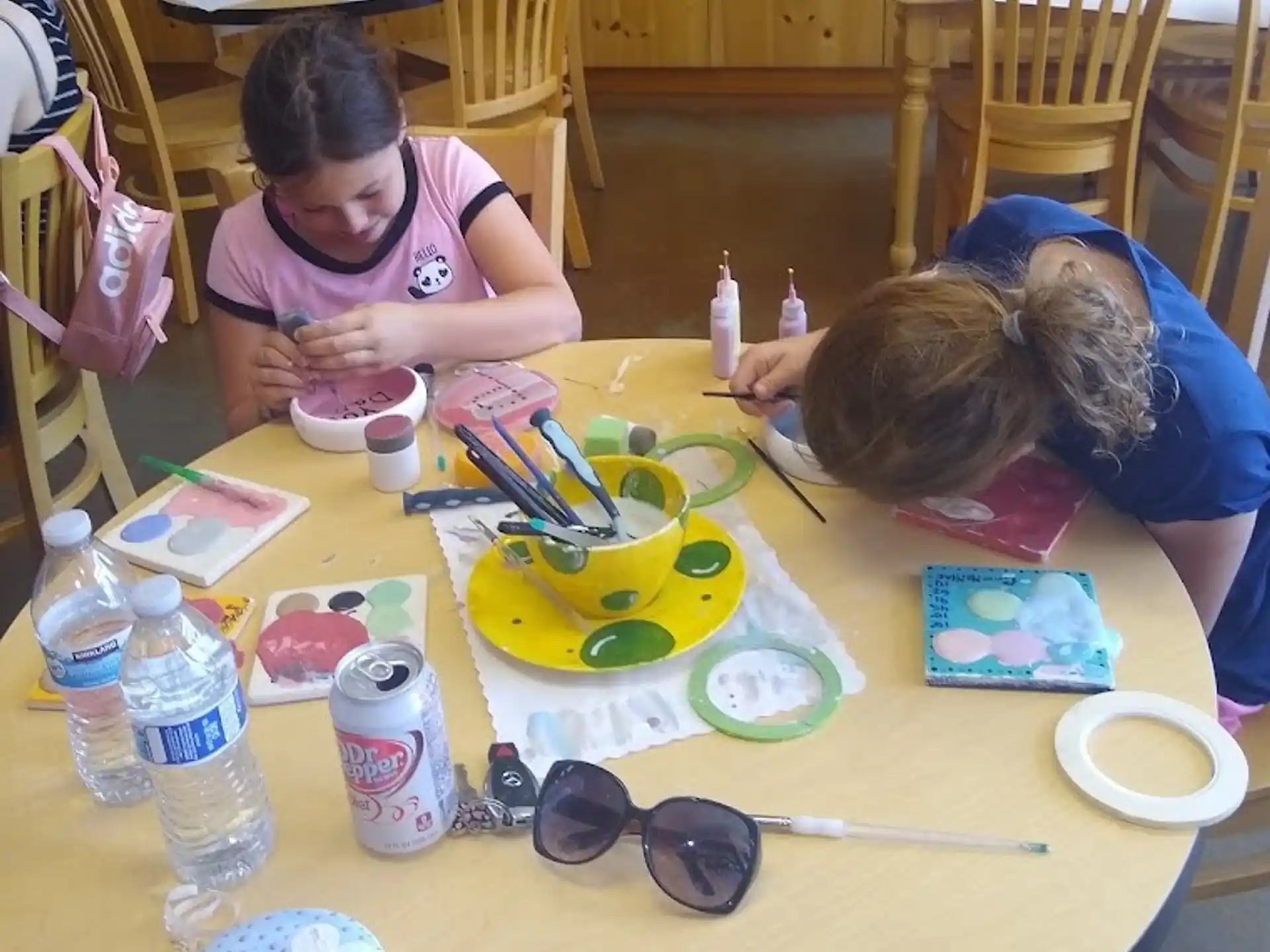 a couple of people painting on a table