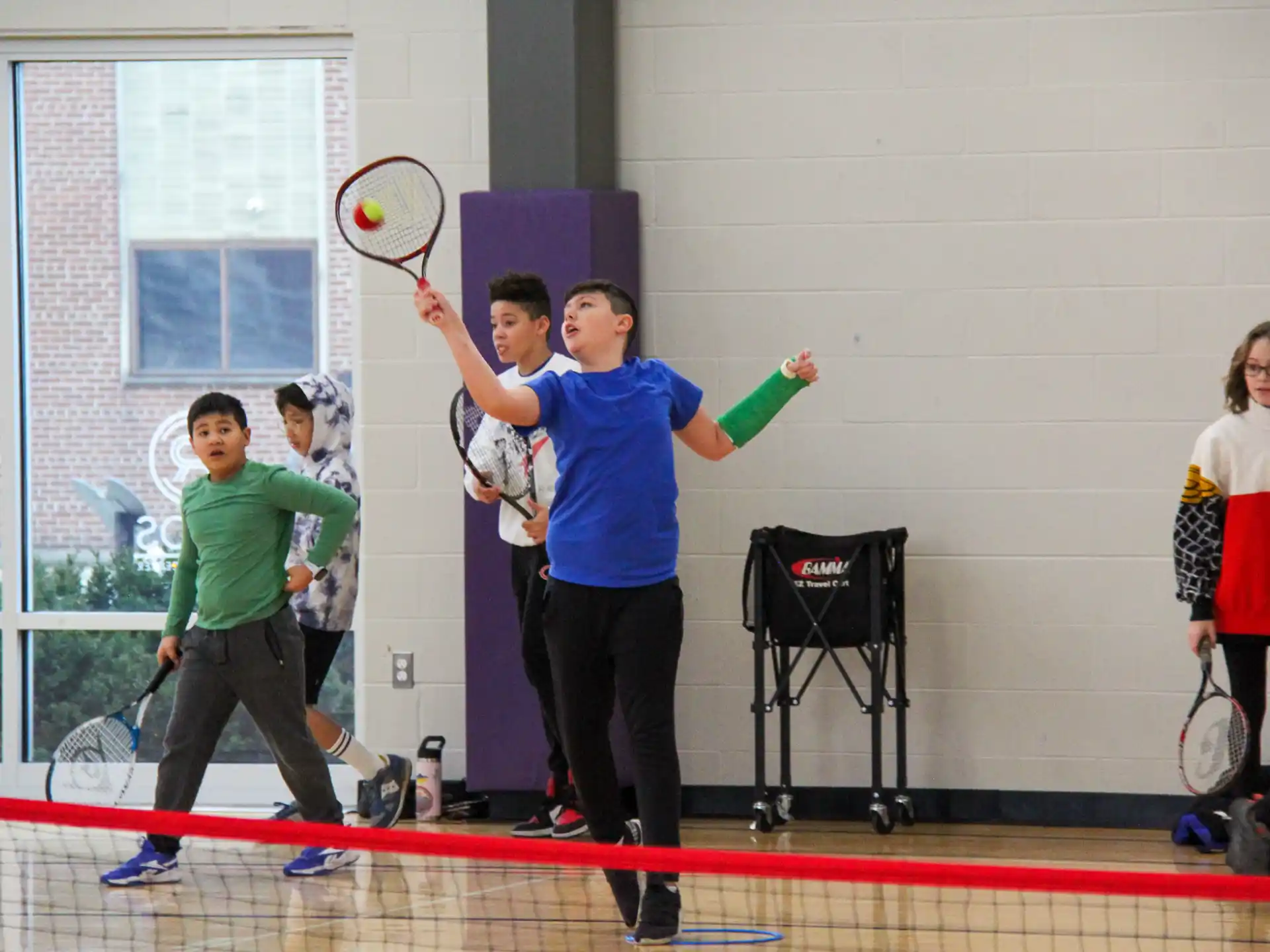 a group of kids playing tennis