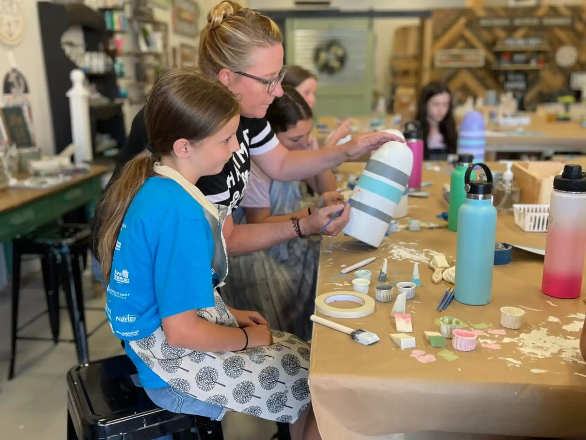 a person helping a young girl with a gift