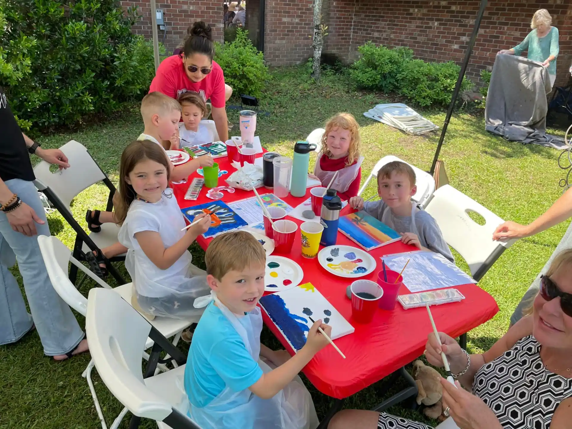 a group of people sitting around a table outside